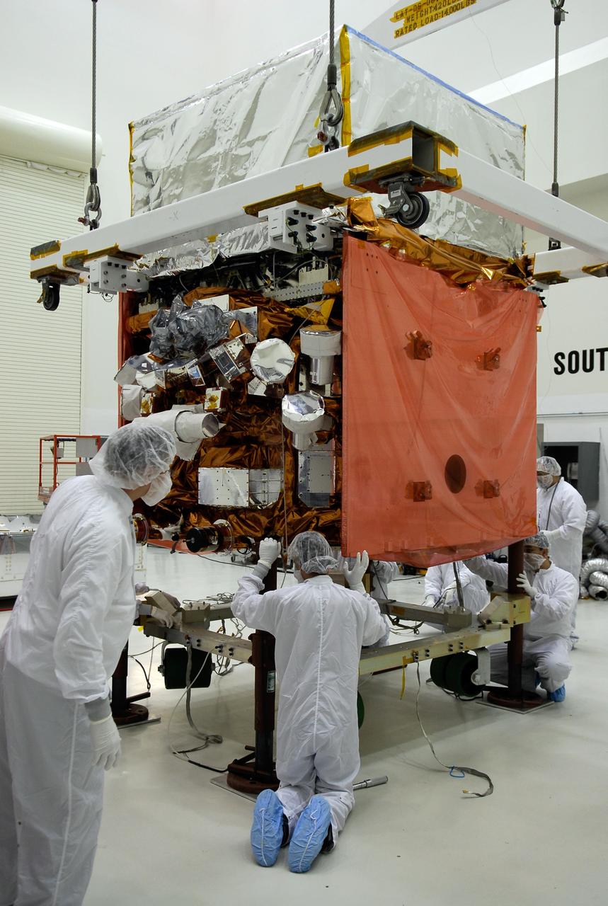 KENNEDY SPACE CENTER, FLA. -- In the Astrotech payload processing facility, General Dynamics technicians keep watch as NASA's Gamma-Ray Large Area Space Telescope, or GLAST, is lowered onto a work stand. There GLAST will undergo a complete checkout of the scientific instruments aboard. . The telescope will launch aboard a Delta II rocket May 16 from Launch Pad 17-B on Cape Canaveral Air Force Station. A powerful space observatory, the GLAST will explore the most extreme environments in the universe, and answer questions about supermassive black hole systems, pulsars and the origin of cosmic rays. It also will study the mystery of powerful explosions known as gamma-ray bursts. Photo credit: NASA/Kim Shiflett