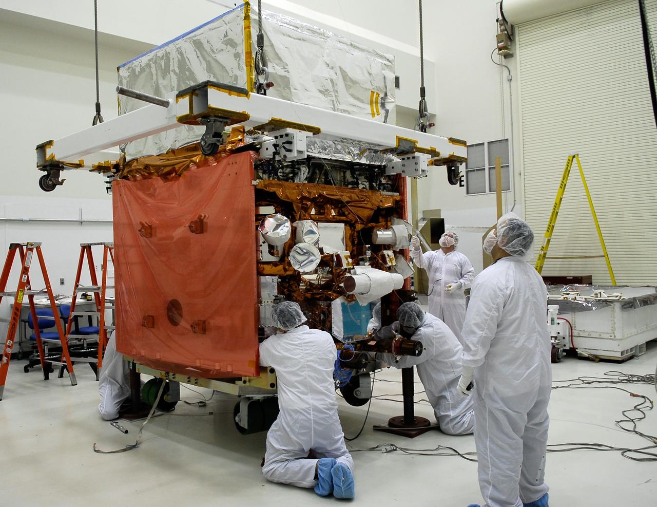 KENNEDY SPACE CENTER, FLA. -- In the Astrotech payload processing facility, General Dynamics technicians secure NASA's Gamma-Ray Large Area Space Telescope, or GLAST, onto a work stand. There GLAST will undergo a complete checkout of the scientific instruments aboard. The telescope will launch aboard a Delta II rocket May 16 from Launch Pad 17-B on Cape Canaveral Air Force Station. A powerful space observatory, the GLAST will explore the most extreme environments in the universe, and answer questions about supermassive black hole systems, pulsars and the origin of cosmic rays. It also will study the mystery of powerful explosions known as gamma-ray bursts. Photo credit: NASA/Kim Shiflett