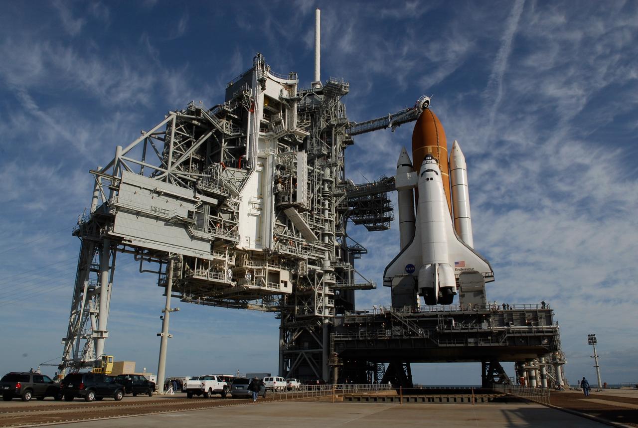 KENNEDY SPACE CENTER, FLA. -- On Launch Pad 39A at NASA's Kennedy Space Center, rollback of the rotating service structure (at left) reveals space shuttle Endeavour atop the mobile launcher platform. First motion was at 8:23 a.m. and rollback was complete at 8:55 a.m. Above the orange external tank is seen the "beanie cap" at the end of the gaseous oxygen vent arm, extending from the fixed service structure. Vapors are created as the liquid oxygen in the external tank boil off. The hood vents the gaseous oxygen vapors away from the space shuttle vehicle. Below is the orbiter access arm with the White Room at the end, flush against the shuttle. The crew gains access into the orbiter through the White Room. On either side of the main engines and below the wings are the tail service masts, which provide several umbilical connections to the orbiter, including a liquid-oxygen line through one and a liquid-hydrogen line through another. The rotating structure provides protected access to the orbiter for changeout and servicing of payloads at the pad. The structure is supported by a rotating bridge that pivots about a vertical axis on the west side of the pad's flame trench. After the RSS is rolled back, the orbiter is ready for fuel cell activation and external tank cryogenic propellant loading operations. The pad is cleared to the perimeter gate for operations to fill the external tank with about 500,000 gallons of cryogenic propellants used by the shuttle’s main engines. This is done at the pad approximately eight hours before the scheduled launch. Endeavour and its crew will deliver the first section of the Japan Aerospace Exploration Agency's Kibo laboratory and the Canadian Space Agency's two-armed robotic system, Dextre. Launch is scheduled for 2:28 a.m. EDT March 11. Photo credit: NASA/Kim Shiflett