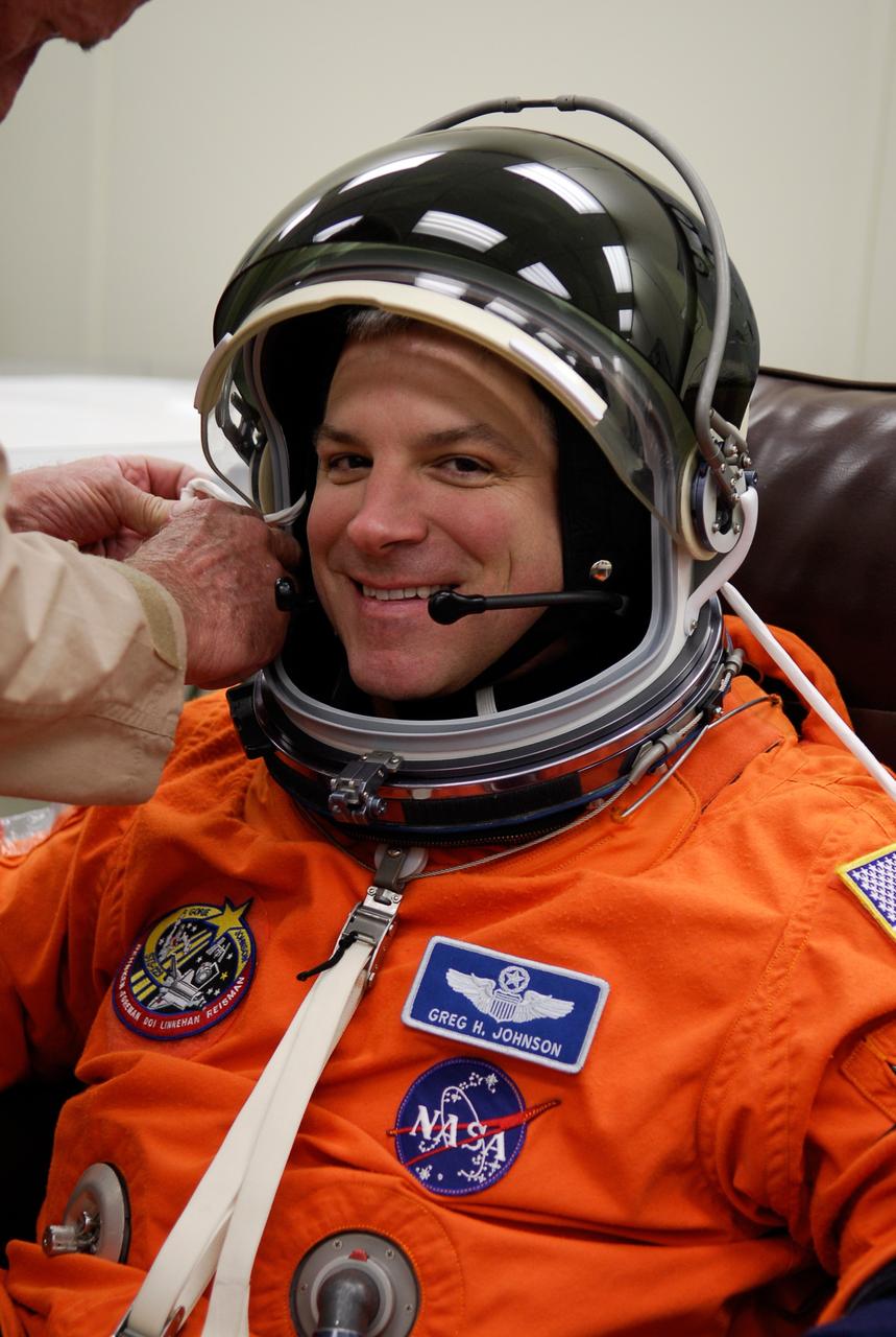KENNEDY SPACE CENTER, FLA. -- STS-123 Pilot Gregory H. Johnson is helped with his helmet during suitup before heading to Launch Pad 39A for liftoff on space shuttle Endeavour. The crew will make a record-breaking 16-day mission to the International Space Station. On STS-123, Endeavour and its crew will deliver the first section of the Japan Aerospace Exploration Agency's Kibo laboratory and the Canadian Space Agency's two-armed robotic system, Dextre. Launch is scheduled for 2:28 a.m. EDT March 11. Photo credit: NASA/Kim Shiflett
