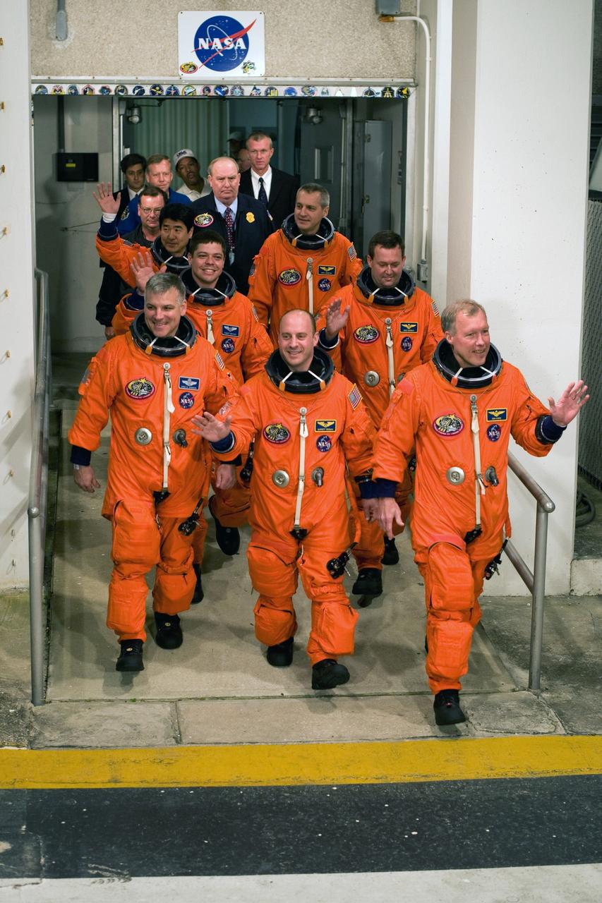 KENNEDY SPACE CENTER, FLA. -- Space shuttle Endeavour's STS-123 crew members acknowledge well-wishers as they exit the Operations and Checkout Building. In front are Pilot Gregory H. Johnson (left), Mission Specialist Garrett Reisman (center) and Commander Dominic Gorie (right). In the middle are Mission Specialists Robert L. Behnken and Mike Foreman. In the back are Takao Doi of the Japan Aerospace Exploration Agency and Rick Linnehan. Reisman will remain on the International Space Station as a flight engineer. The crew will make a record-breaking 16-day mission to the International Space Station. On STS-123, Endeavour and its crew will deliver the first section of the Japan Aerospace Exploration Agency's Kibo laboratory and the Canadian Space Agency's two-armed robotic system, Dextre. Launch is scheduled for 2:28 a.m. EDT March 11. Photo courtesy of Scott Andrews