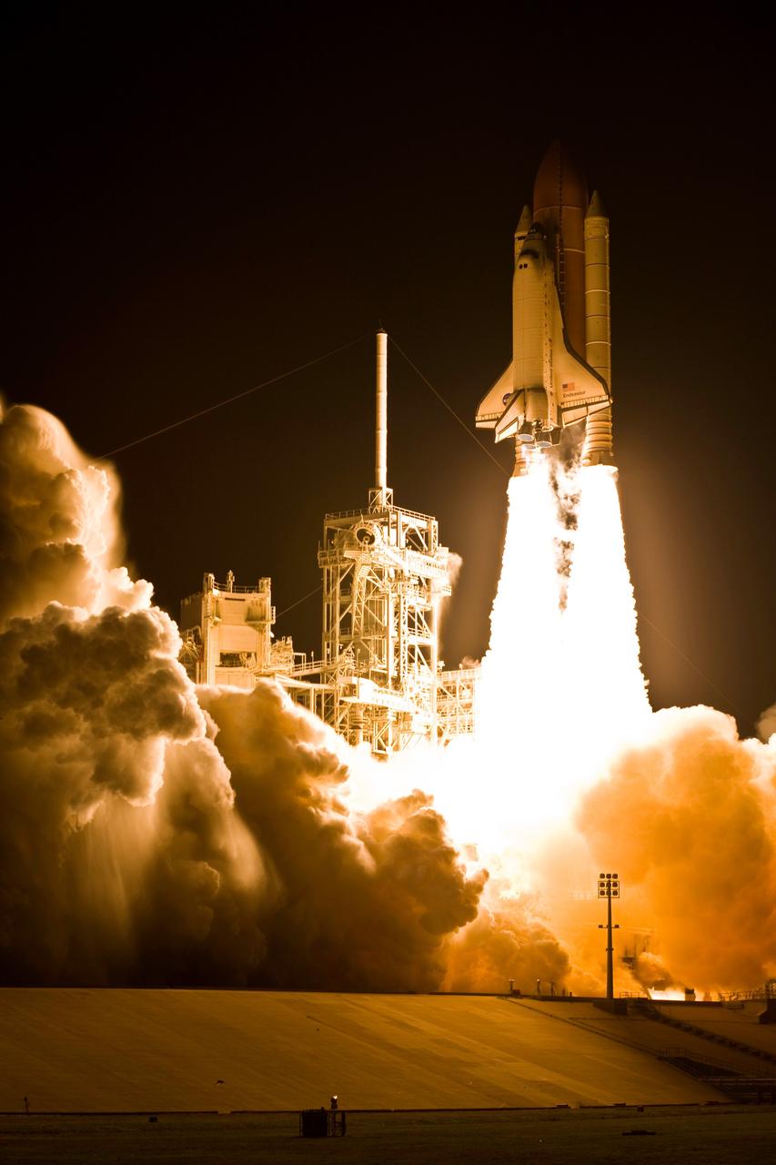 KENNEDY SPACE CENTER, FLA. --    Light-filled clouds of smoke and steam roll across Launch Pad 39A at NASA's Kennedy Space Center as space shuttle Endeavour roars into the night sky atop twin towers of flame on the STS-123 mission.  Liftoff was on time at 2:28 a.m. EDT.  Endeavour's crew will make a record-breaking 16-day mission to the International Space Station and deliver the first section of the Japan Aerospace Exploration Agency's Kibo laboratory and the Canadian Space Agency's two-armed robotic system, Dextre.  Photo courtesy of Scott Andrews
