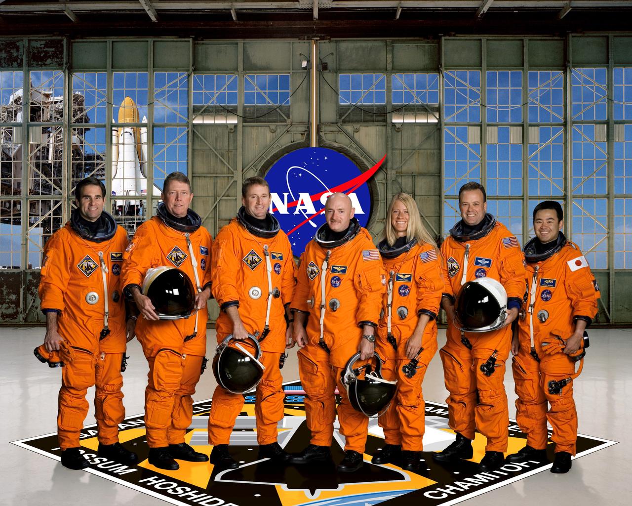 KENNEDY SPACE CENTER, FLA. --- STS124-S-002 --- These seven astronauts take a break from training to pose for the STS-124 crew portrait. From the left are astronauts Gregory E. Chamitoff, Michael E. Fossum, both STS-124 mission specialists; Kenneth T. Ham, pilot; Mark E. Kelly, commander; Karen L. Nyberg, Ronald J. Garan and Japan Aerospace Exploration Agency's (JAXA) Akihiko Hoshide, all mission specialists. Chamitoff is scheduled to join Expedition 17 as flight engineer after launching to the International Space Station on mission STS-124. The crewmembers are attired in training versions of their shuttle launch and entry suits.