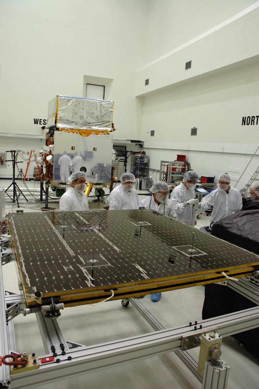 KENNEDY SPACE CENTER, FLA. - In the Astrotech payload processing facility, General Dynamics technicians prepare to install the twin solar arrays on NASA's Gamma-Ray Large Area Space Telescope, or GLAST. The telescope will launch aboard a Delta II rocket May 16 from Launch Pad 17-B on Cape Canaveral Air Force Station. A powerful space observatory, the GLAST will explore the most extreme environments in the universe, and answer questions about supermassive black hole systems, pulsars and the origin of cosmic rays. It also will study the mystery of powerful explosions known as gamma-ray bursts. Photo credit: NASA/Chris Rhodes