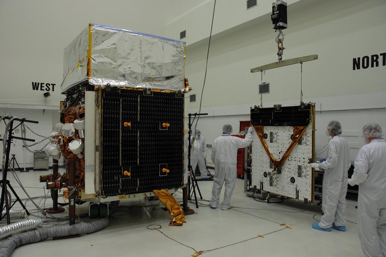 KENNEDY SPACE CENTER, FLA. - In the Astrotech payload processing facility, General Dynamics technicians move the second of twin solar arrays toward NASA's Gamma-Ray Large Area Space Telescope, or GLAST. The telescope will launch aboard a Delta II rocket May 16 from Launch Pad 17-B on Cape Canaveral Air Force Station. A powerful space observatory, the GLAST will explore the most extreme environments in the universe, and answer questions about supermassive black hole systems, pulsars and the origin of cosmic rays. It also will study the mystery of powerful explosions known as gamma-ray bursts. Photo credit: NASA/Chris Rhodes