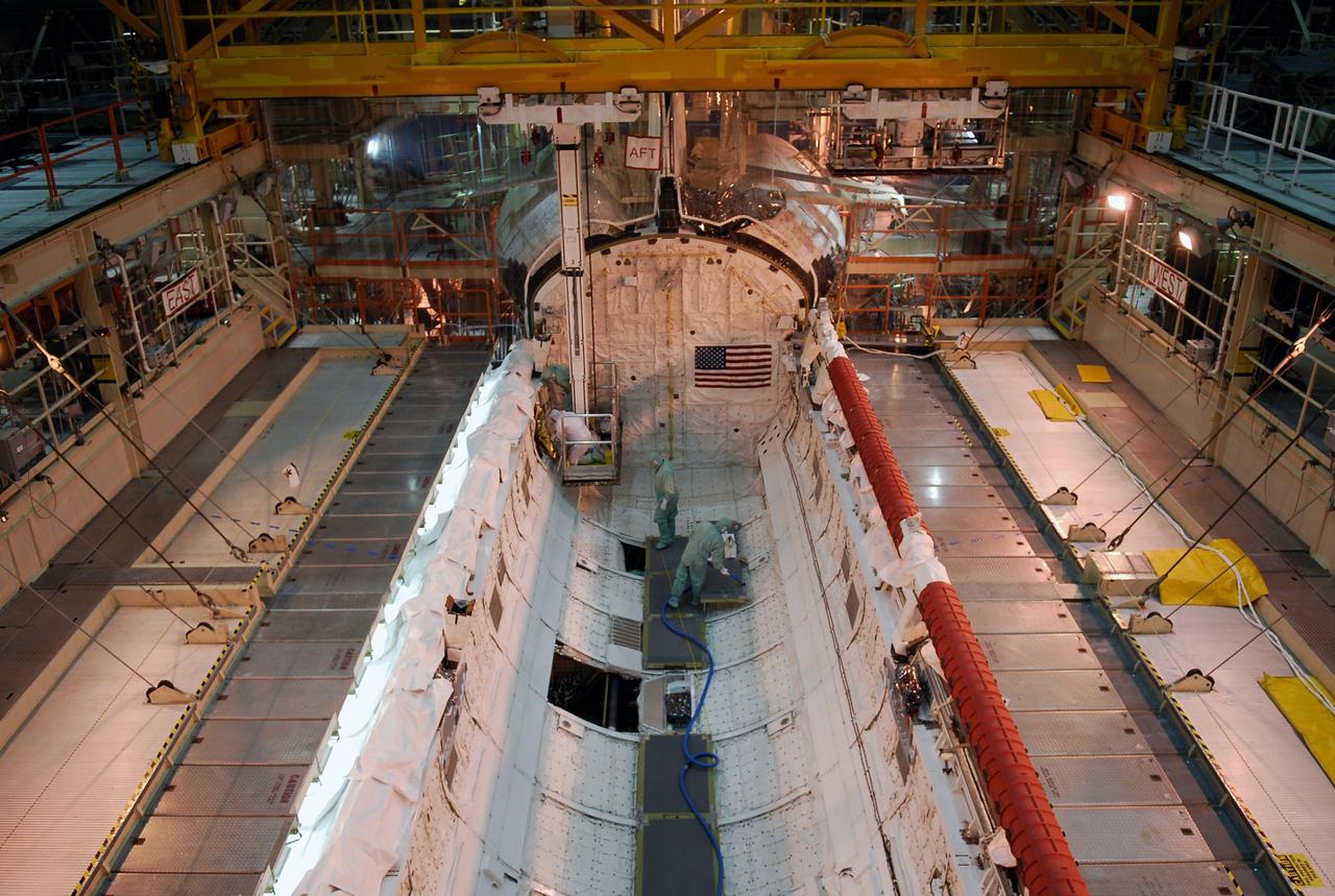 CAPE CANAVERAL, Fla. --- In the Orbiter Processing Facility at NASA's Kennedy Space Center, workers prepare space shuttle Discovery's payload bay for payload installation. The launch of Discovery on its STS-124 mission is targeted for April 24. On the right side is the shuttle's robotic arm. On the mission, Discovery will transport the Kibo Japanese Experiment Module - Pressurized Module and the Japanese Remote Manipulator System to the International Space Station. Photo credit: NASA/Kim Shiflett