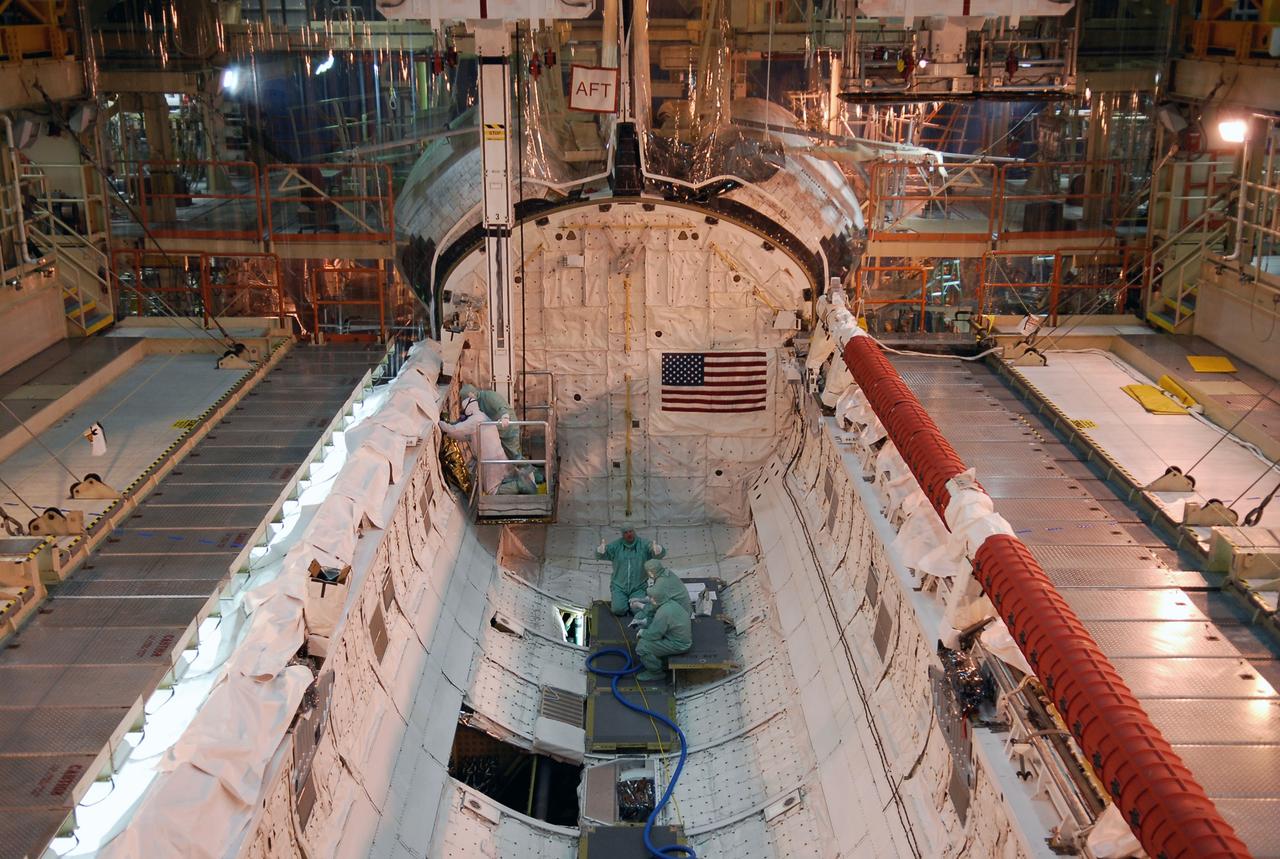 CAPE CANAVERAL, Fla. --- In the Orbiter Processing Facility at NASA's Kennedy Space Center, workers prepare space shuttle Discovery's payload bay for payload installation. The launch of Discovery on its STS-124 mission is targeted for April 24. On the right side is the shuttle's robotic arm. On the mission, Discovery will transport the Kibo Japanese Experiment Module - Pressurized Module and the Japanese Remote Manipulator System to the International Space Station. Photo credit: NASA/Kim Shiflett