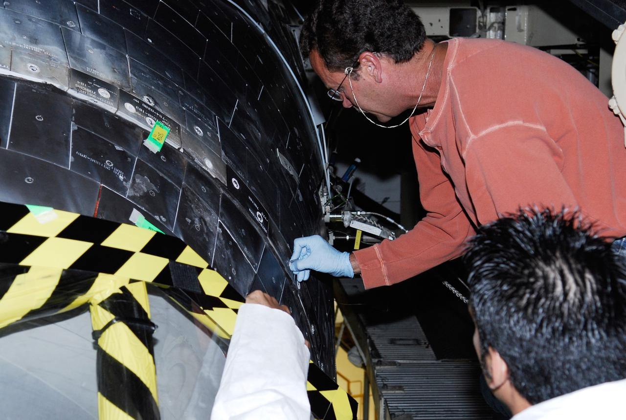 CAPE CANAVERAL, Fla. --- In the Orbiter Processing Facility at NASA's Kennedy Space Center, United Space Alliance technicians work on the thermal protection system tiles on space shuttle Discovery. The launch of Discovery on its STS-124 mission is targeted for April 24. On the mission, Discovery will transport the Kibo Japanese Experiment Module - Pressurized Module and the Japanese Remote Manipulator System to the International Space Station. Photo credit: NASA/Kim Shiflett