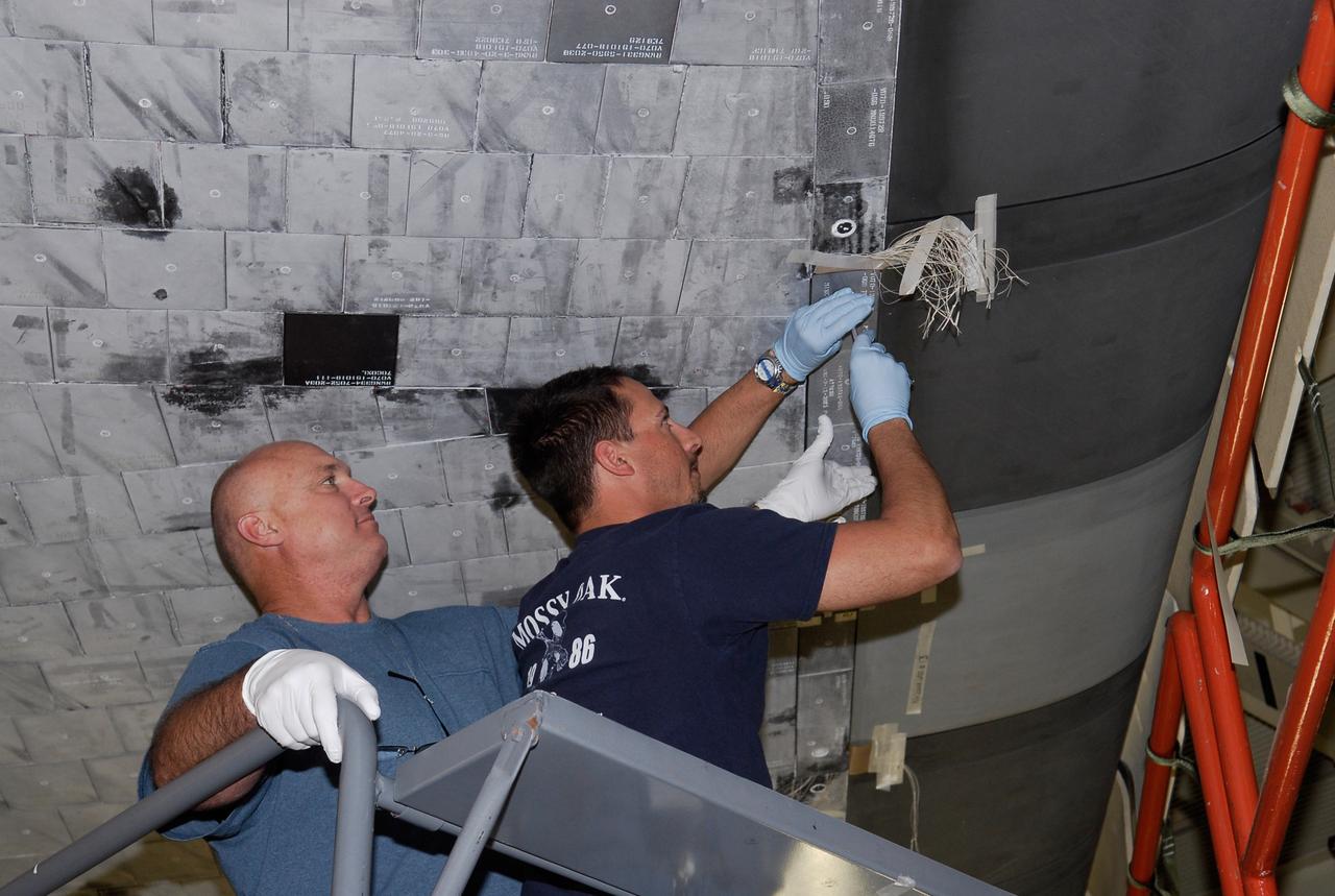 CAPE CANAVERAL, Fla. --- In the Orbiter Processing Facility at NASA's Kennedy Space Center, United Space Alliance technicians work on the thermal protection system tiles on space shuttle Discovery. The launch of Discovery on the STS-124 mission is targeted for April 24. On the mission, Discovery will transport the Kibo Japanese Experiment Module - Pressurized Module and the Japanese Remote Manipulator System to the International Space Station. Photo credit: NASA/Kim Shiflett