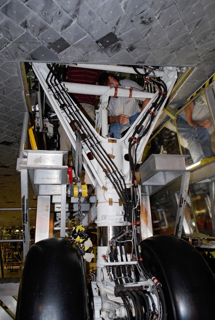 CAPE CANAVERAL, Fla. --- In the Orbiter Processing Facility at NASA's Kennedy Space Center, United Space Alliance technicians work on the thermal protection system tiles around the landing gear on space shuttle Discovery. The launch of Discovery on the STS-124 mission is targeted for April 24. On the mission, Discovery will transport the Kibo Japanese Experiment Module - Pressurized Module and the Japanese Remote Manipulator System to the International Space Station. Photo credit: NASA/Kim Shiflett