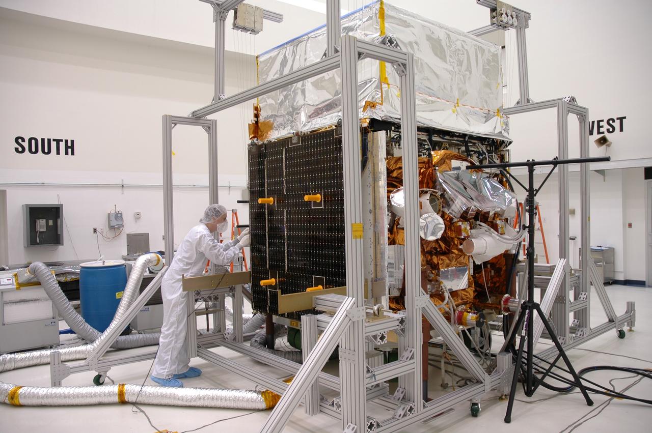CAPE CANAVERAL, Fla. --- In the Astrotech payload processing facility, a General Dynamics technician prepares to test the deployment mechanism on the solar arrays on NASA's Gamma-Ray Large Area Space Telescope, or GLAST. The telescope will launch aboard a Delta II rocket May 16 from Launch Pad 17-B on Cape Canaveral Air Force Station. A powerful space observatory, the GLAST will explore the most extreme environments in the universe, and answer questions about supermassive black hole systems, pulsars and the origin of cosmic rays. It also will study the mystery of powerful explosions known as gamma-ray bursts. Photo credit: NASA/Jim Grossmann