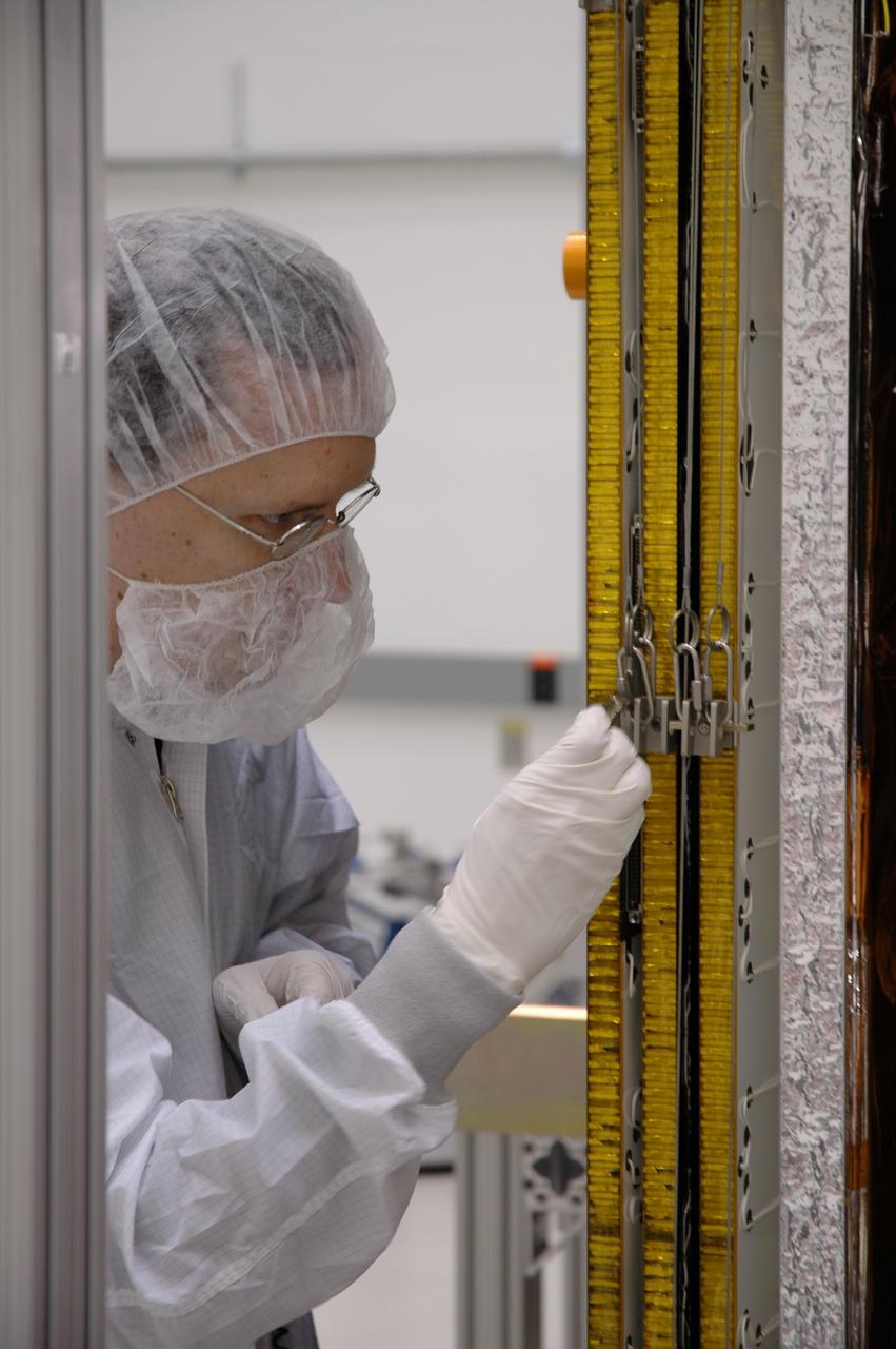 CAPE CANAVERAL, Fla. --- In the Astrotech payload processing facility, a General Dynamics technician prepares to test the deployment mechanism of the solar arrays on NASA's Gamma-Ray Large Area Space Telescope, or GLAST. The telescope will launch aboard a Delta II rocket May 16 from Launch Pad 17-B on Cape Canaveral Air Force Station. A powerful space observatory, the GLAST will explore the most extreme environments in the universe, and answer questions about supermassive black hole systems, pulsars and the origin of cosmic rays. It also will study the mystery of powerful explosions known as gamma-ray bursts. Photo credit: NASA/Jim Grossmann