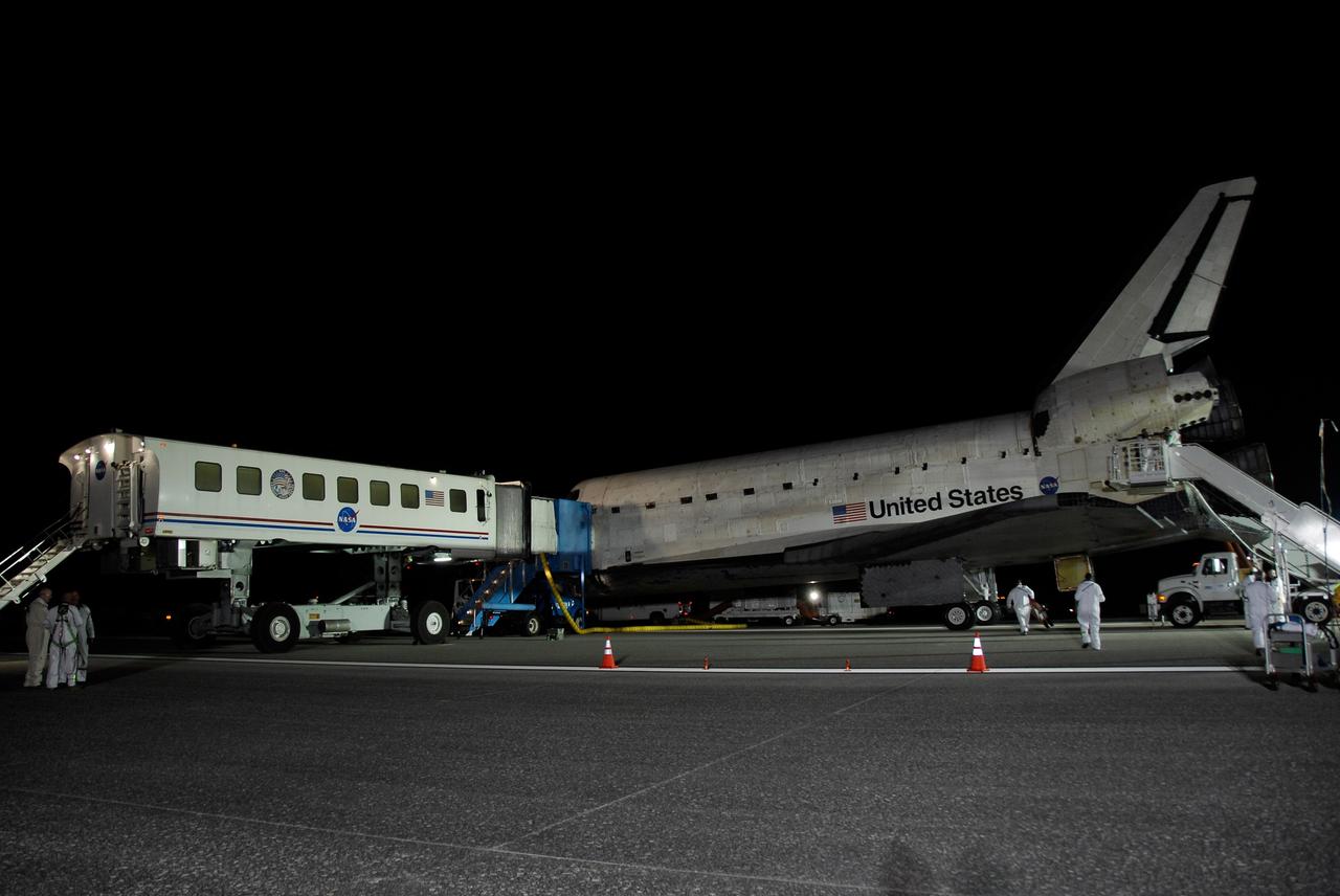 CAPE CANAVERAL, Fla. --- A crew hatch access vehicle is positioned against space shuttle Endeavour on Runway 15 at NASA Kennedy Space Center's Shuttle Landing Facility at the end of the STS-123 mission, a 16-day flight to the International Space Station.  The vehicle provides a "white room" in which a physician performs a brief preliminary medical examination of the crew members before they leave the shuttle.  This was the 16th night landing at Kennedy.  The main landing gear touched down at 8:39:08 p.m. EDT.  The nose landing gear touched down at 8:39:17 p.m. and wheel stop was at 8:40:41 p.m.  The mission completed nearly 6.6 million miles.  The landing was on the second opportunity after the first was waved off due to unstable weather in the Kennedy Space Center area.   The STS-123 mission delivered the first segment of the Japan Aerospace Exploration Agency's Kibo laboratory and the Canadian Space Agency's two-armed robotic system, known as Dextre.  Photo credit: NASA/Kim Shiflett