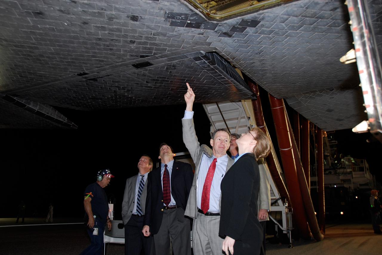 CAPE CANAVERAL, Fla. --- NASA managers examine the thermal protection system tile under space shuttle Endeavour on Runway 15 at Kennedy Space Center's Shuttle Landing Facility at the end of the STS-123 mission, a 16-day flight to the International Space Station.  From left are a member of the convoy crew, Shuttle Launch Director Mike Leinbach, Mission Management Team Chairman LeRoy Cain, NASA Administrator Mike Griffin and NASA Deputy Administrator Shana Dale.  Behind them is Kennedy Space Center Director Bill Parsons.  This was the 16th night landing at Kennedy.  The main landing gear touched down at 8:39:08 p.m. EDT.  The nose landing gear touched down at 8:39:17 p.m. and wheel stop was at 8:40:41 p.m.  The mission completed nearly 6.6 million miles.  The landing was on the second opportunity after the first was waved off due to unstable weather in the Kennedy Space Center area.   The STS-123 mission delivered the first segment of the Japan Aerospace Exploration Agency's Kibo laboratory and the Canadian Space Agency's two-armed robotic system, known as Dextre.  Photo credit: NASA/Kim Shiflett