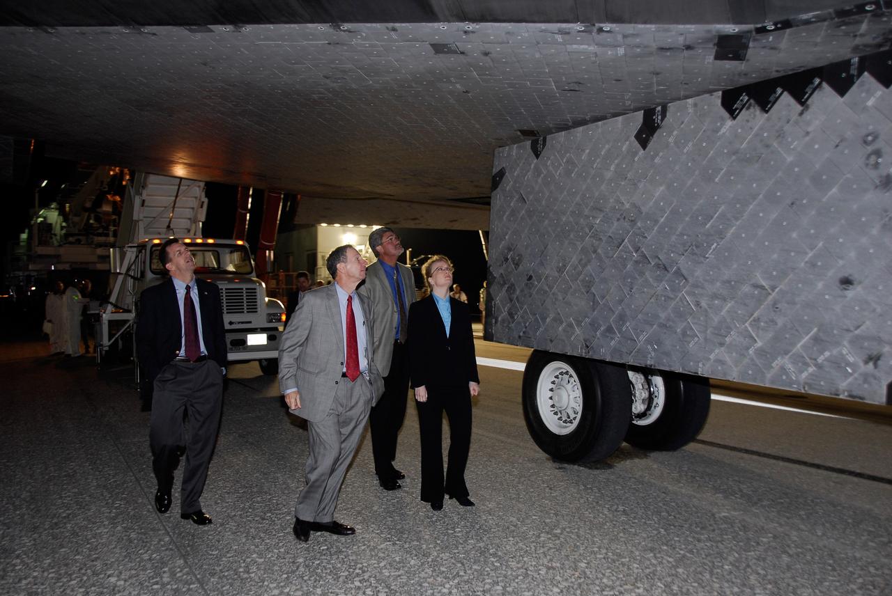 CAPE CANAVERAL, Fla. --- NASA managers examine the thermal protection system tile under space shuttle Endeavour on Runway 15 at Kennedy Space Center's Shuttle Landing Facility at the end of the STS-123 mission, a 16-day flight to the International Space Station.  From left are Mission Management Team Chairman LeRoy Cain, NASA Administrator Mike Griffin, Kennedy Space Center Director Bill Parsons and NASA Deputy Administrator Shana Dale.  This was the 16th night landing at Kennedy.  The main landing gear touched down at 8:39:08 p.m. EDT.  The nose landing gear touched down at 8:39:17 p.m. and wheel stop was at 8:40:41 p.m.  The mission completed nearly 6.6 million miles.  The landing was on the second opportunity after the first was waved off due to unstable weather in the Kennedy Space Center area.   The STS-123 mission delivered the first segment of the Japan Aerospace Exploration Agency's Kibo laboratory and the Canadian Space Agency's two-armed robotic system, known as Dextre.  Photo credit: NASA/Kim Shiflett
