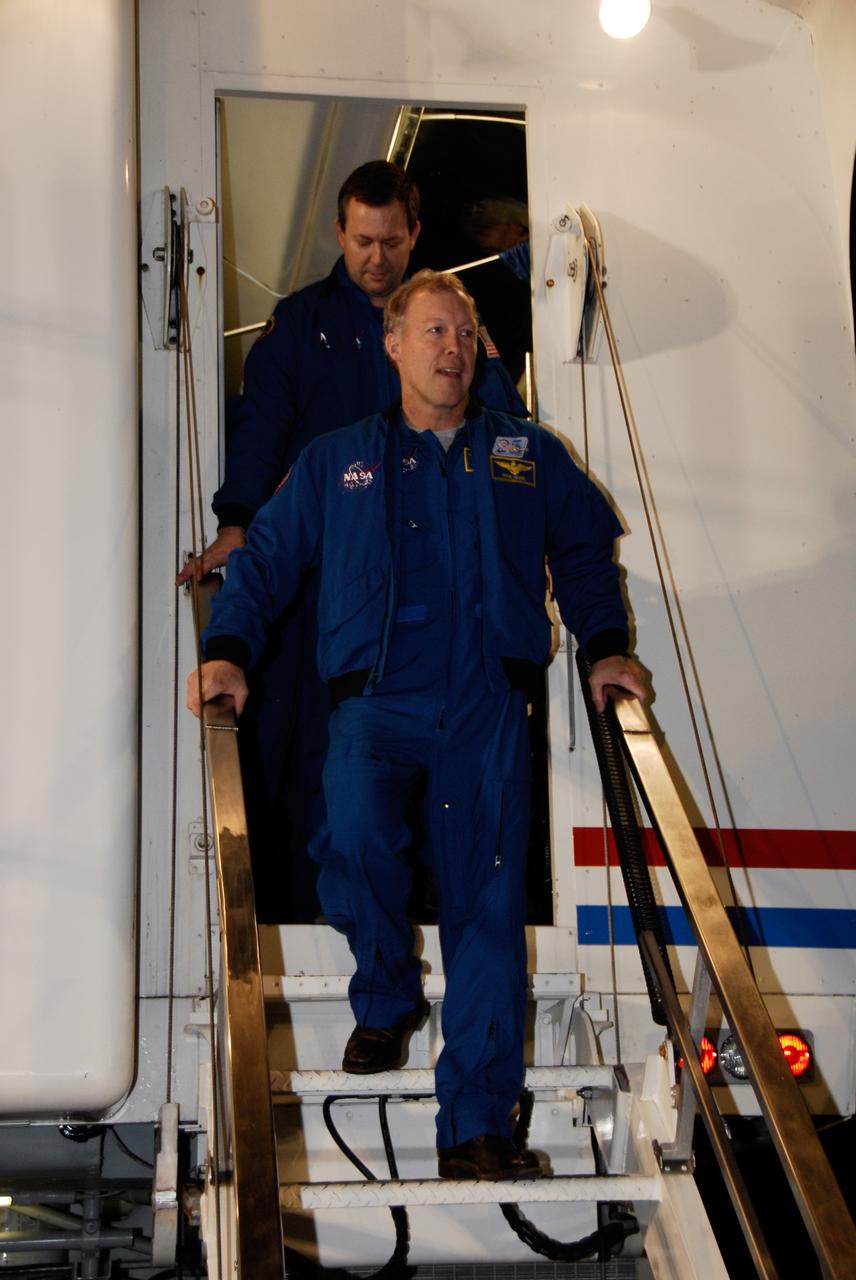 CAPE CANAVERAL, Fla. --- STS-123 Commander Dominic Gorie, in front, and Mission Specialist Mike Foreman exit the crew transport vehicle at NASA Kennedy Space Center's Shuttle Landing Facility.  The vehicle provides a "white room" in which a physician performs a brief preliminary medical examination of the crew members before they leave the shuttle.  Space shuttle Endeavour landed on Runway 15 to end the STS-123 mission, a 16-day flight to the International Space Station.  This was the 16th night landing at Kennedy.  The main landing gear touched down at 8:39:08 p.m. EDT.  The nose landing gear touched down at 8:39:17 p.m. and wheel stop was at 8:40:41 p.m.  The mission completed nearly 6.6 million miles.  The landing was on the second opportunity after the first was waved off due to unstable weather in the Kennedy Space Center area.   The STS-123 mission delivered the first segment of the Japan Aerospace Exploration Agency's Kibo laboratory and the Canadian Space Agency's two-armed robotic system, known as Dextre.  Photo credit: NASA/Kim Shiflett