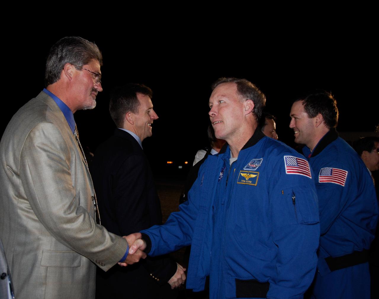 CAPE CANAVERAL, Fla. --- STS-123 Commander Dominic Gorie, right front, is greeted by Kennedy Space Center Director Bill Parsons at NASA Kennedy Space Center's Shuttle Landing Facility.  Behind them, LeRoy Cain, chair of the mission management team, welcomes Mission Specialist Mike Foreman.  Space shuttle Endeavour landed on Runway 15 to end the STS-123 mission, a 16-day flight to the International Space Station.  This was the 16th night landing at Kennedy.  The main landing gear touched down at 8:39:08 p.m. EDT.  The nose landing gear touched down at 8:39:17 p.m. and wheel stop was at 8:40:41 p.m.  The mission completed nearly 6.6 million miles.  The landing was on the second opportunity after the first was waved off due to unstable weather in the Kennedy Space Center area.  The STS-123 mission delivered the first segment of the Japan Aerospace Exploration Agency's Kibo laboratory and the Canadian Space Agency's two-armed robotic system, known as Dextre.  Photo credit: NASA/Kim Shiflett