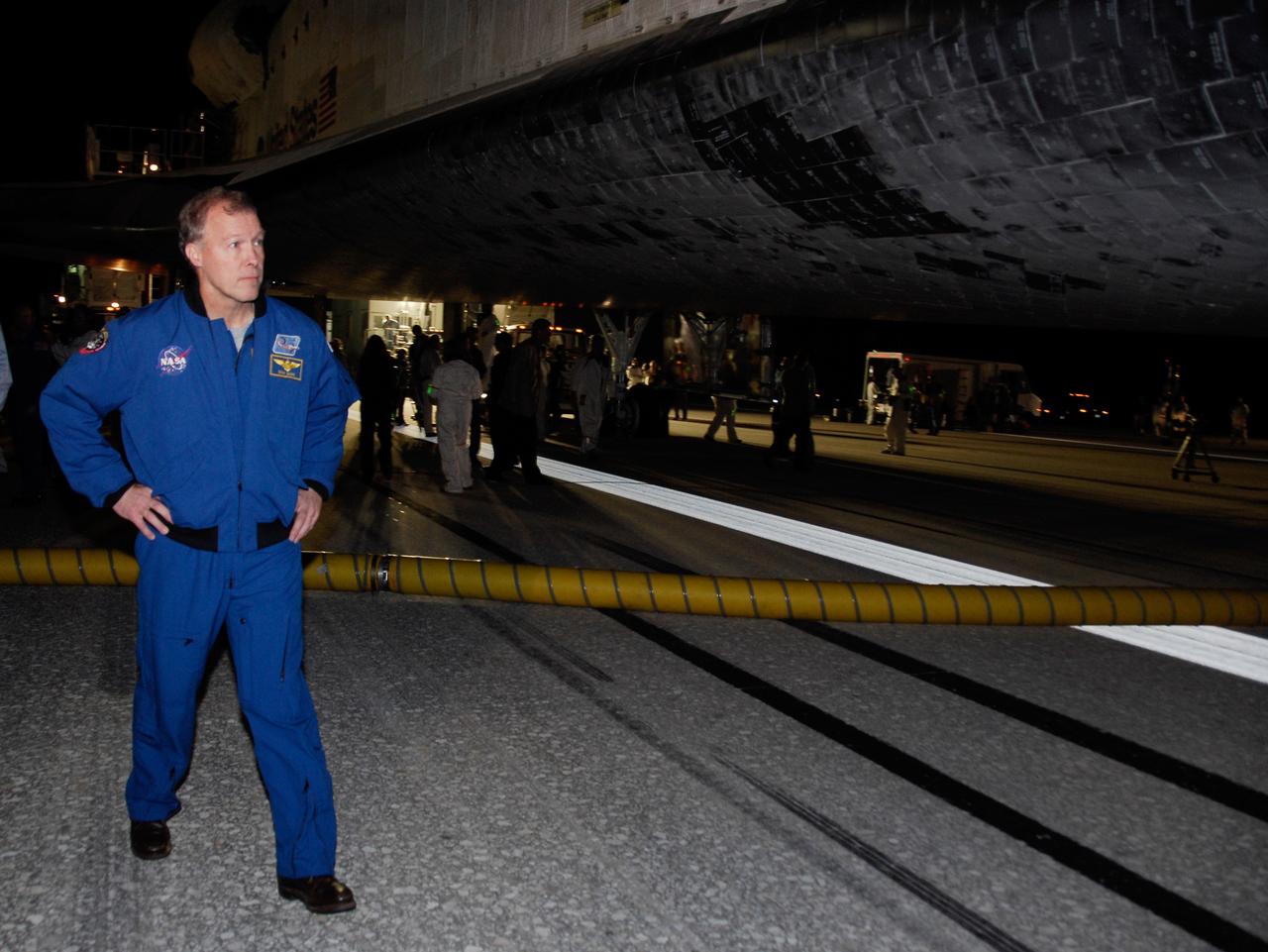 CAPE CANAVERAL, Fla. --- STS-123 Commander Dominic Gorie inspects the thermal protection system tile on space shuttle Endeavour at NASA Kennedy Space Center's Shuttle Landing Facility.  Endeavour landed on Runway 15 to end the STS-123 mission, a 16-day flight to the International Space Station.  This was the 16th night landing at Kennedy.  The main landing gear touched down at 8:39:08 p.m. EDT.  The nose landing gear touched down at 8:39:17 p.m. and wheel stop was at 8:40:41 p.m.  The mission completed nearly 6.6 million miles.  The landing was on the second opportunity after the first was waved off due to unstable weather in the Kennedy Space Center area.   The STS-123 mission delivered the first segment of the Japan Aerospace Exploration Agency's Kibo laboratory and the Canadian Space Agency's two-armed robotic system, known as Dextre.  Photo credit: NASA/Kim Shiflett
