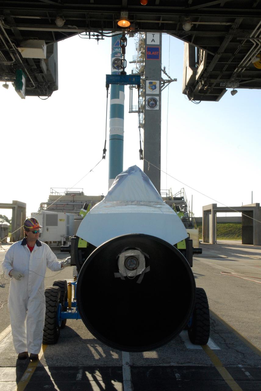 CAPE CANAVERAL, Fla. ---   The first solid rocket motor arrives at Pad 17-B on Cape Canaveral Air Force Station for mating with the Delta II rocket (background) to launch NASA's Gamma-ray Large Area Space Telescope, or GLAST, spacecraft.  A series of nine strap-on solid rocket motors will help power the first stage.The GLAST is a powerful space observatory that will explore the Universe's ultimate frontier, where nature harnesses forces and energies far beyond anything possible on Earth;  probe some of science's deepest questions, such as what our Universe is made of, and search for new laws of physics; explain how black holes accelerate jets of material to nearly light speed; and help crack the mystery of stupendously powerful explosions known as gamma-ray bursts.  Launch is currently planned for May 16 from Pad 17-B.   Photo credit: NASA/Dimitri Gerondidakis