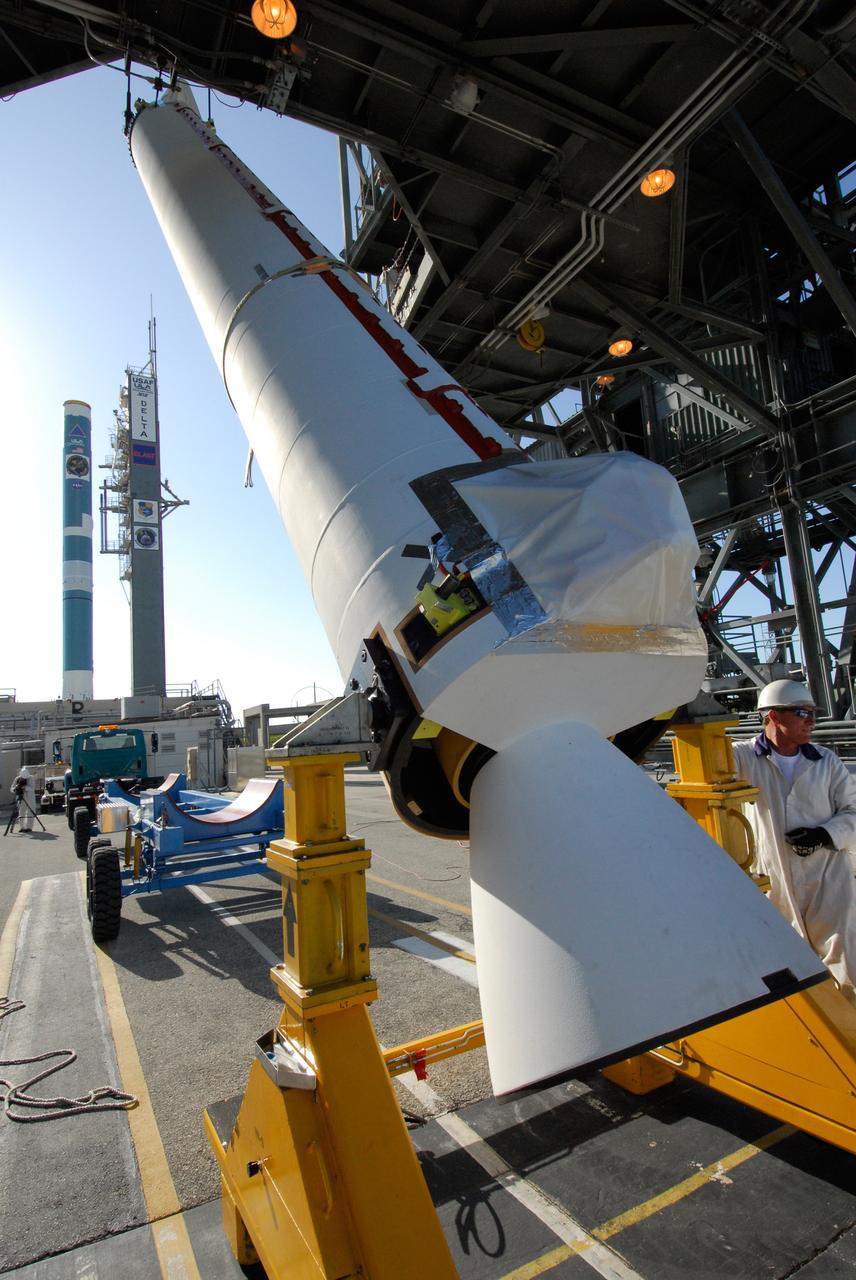 CAPE CANAVERAL, Fla. ---  At Pad 17-B on Cape Canaveral Air Force Station, a solid rocket booster is raised to a vertical position for lifting into the mobile service tower.  There it will be mated with the Delta II rocket to launch NASA's Gamma-ray Large Area Space Telescope, or GLAST, spacecraft.  A series of nine strap-on solid rocket motors will help power the first stage.  The GLAST is a powerful space observatory that will explore the Universe's ultimate frontier, where nature harnesses forces and energies far beyond anything possible on Earth;  probe some of science's deepest questions, such as what our Universe is made of, and search for new laws of physics; explain how black holes accelerate jets of material to nearly light speed; and help crack the mystery of stupendously powerful explosions known as gamma-ray bursts.  Launch is currently planned for May 16 from Pad 17-B.   Photo credit: NASA/Dimitri Gerondidakis