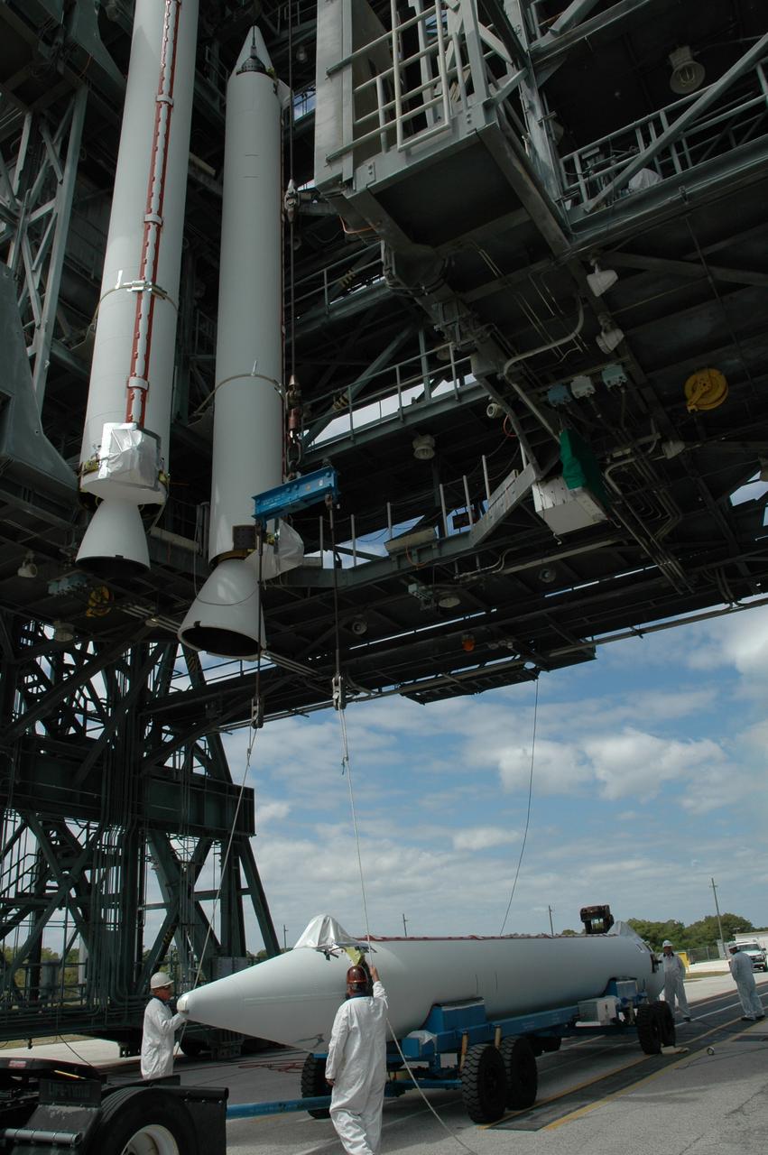 CAPE CANAVERAL, Fla. ---   On Pad 17-B on Cape Canaveral Air Force Station, workers prepare to raise the solid rocket booster to a vertical position.  When it has been raised, the booster will be lifted into the mobile service tower for mating with the Delta II rocket that will launch NASA's Gamma-ray Large Area Space Telescope, or GLAST, spacecraft.  A series of nine strap-on solid rocket motors will help power the first stage.  Because the Delta rocket is configured as a Delta II 7920 Heavy, the boosters are larger than those used on the standard configuration.  The GLAST is a powerful space observatory that will explore the Universe's ultimate frontier, where nature harnesses forces and energies far beyond anything possible on Earth;  probe some of science's deepest questions, such as what our Universe is made of, and search for new laws of physics; explain how black holes accelerate jets of material to nearly light speed; and help crack the mystery of stupendously powerful explosions known as gamma-ray bursts.  Launch is currently planned for May 16 from Pad 17-B.   Photo credit: NASA/Jim Grossmann