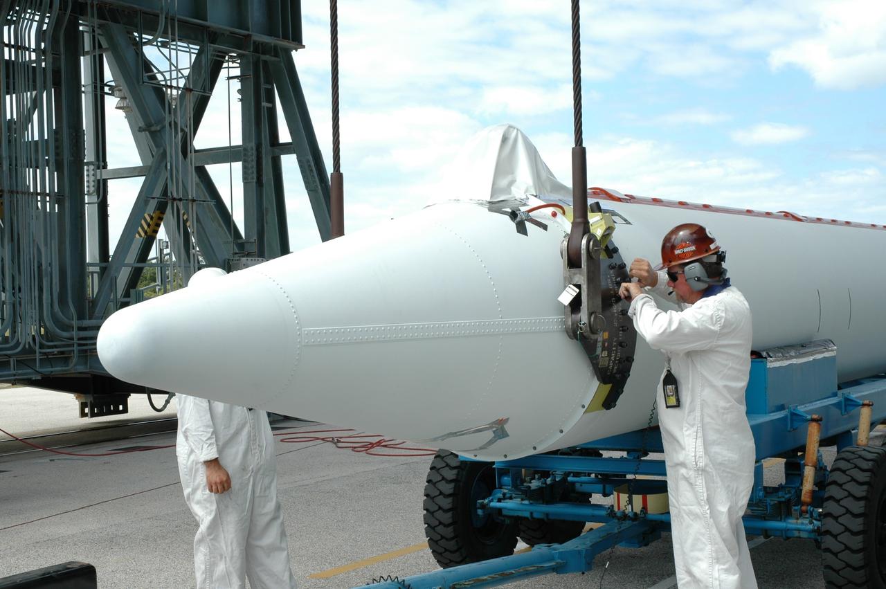 CAPE CANAVERAL, Fla. ---    On Pad 17-B on Cape Canaveral Air Force Station, a worker attaches the crane to a solid rocket booster.  The crane will raise the booster to a vertical position.  When it has been raised, the booster will be lifted into the mobile service tower for mating with the Delta II rocket that will launch NASA's Gamma-ray Large Area Space Telescope, or GLAST, spacecraft.  A series of nine strap-on solid rocket motors will help power the first stage.  Because the Delta rocket is configured as a Delta II 7920 Heavy, the boosters are larger than those used on the standard configuration.  The GLAST is a powerful space observatory that will explore the Universe's ultimate frontier, where nature harnesses forces and energies far beyond anything possible on Earth;  probe some of science's deepest questions, such as what our Universe is made of, and search for new laws of physics; explain how black holes accelerate jets of material to nearly light speed; and help crack the mystery of stupendously powerful explosions known as gamma-ray bursts.  Launch is currently planned for May 16 from Pad 17-B.   Photo credit: NASA/Jim Grossmann