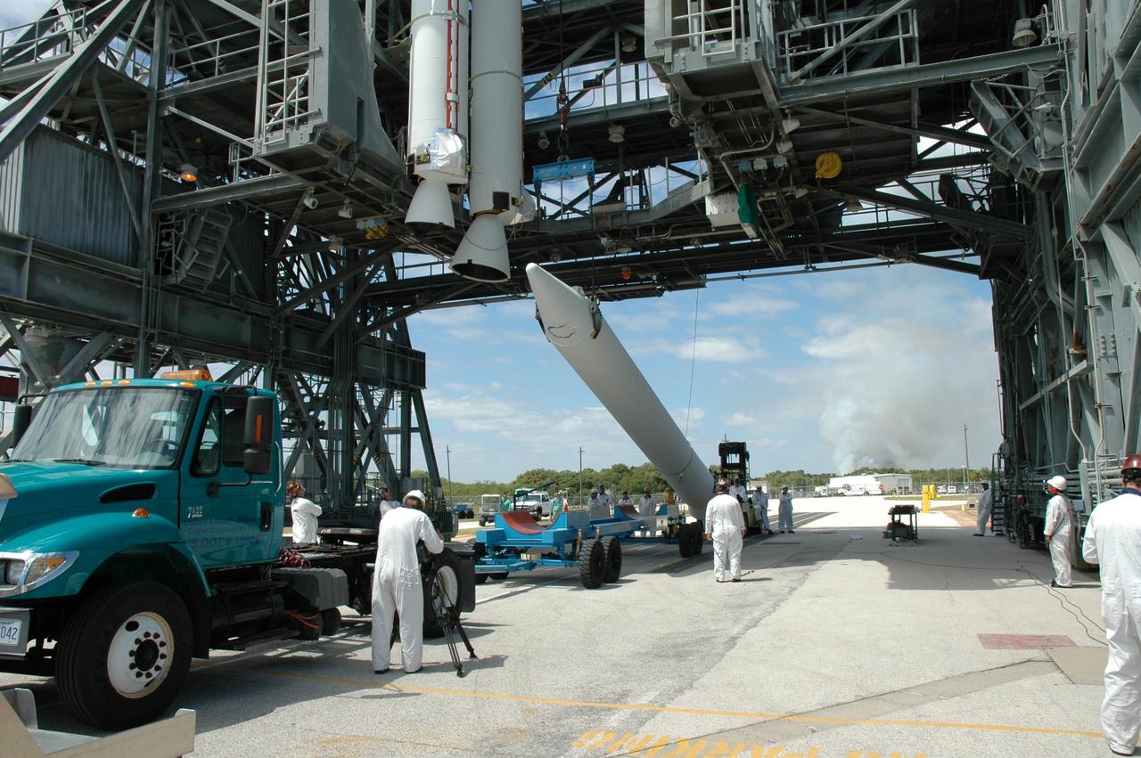 CAPE CANAVERAL, Fla. ---  On Pad 17-B on Cape Canaveral Air Force Station, the solid rocket booster is raised from its transporter toward a vertical position. When it has been raised, the booster will be lifted into the mobile service tower for mating with the Delta II rocket that will launch NASA's Gamma-ray Large Area Space Telescope, or GLAST, spacecraft.  Two other boosters are already in place.  A series of nine strap-on solid rocket motors will help power the first stage.  Because the Delta rocket is configured as a Delta II 7920 Heavy, the boosters are larger than those used on the standard configuration.  The GLAST is a powerful space observatory that will explore the Universe's ultimate frontier, where nature harnesses forces and energies far beyond anything possible on Earth;  probe some of science's deepest questions, such as what our Universe is made of, and search for new laws of physics; explain how black holes accelerate jets of material to nearly light speed; and help crack the mystery of stupendously powerful explosions known as gamma-ray bursts.  Launch is currently planned for May 16 from Pad 17-B.   Photo credit: NASA/Jim Grossmann