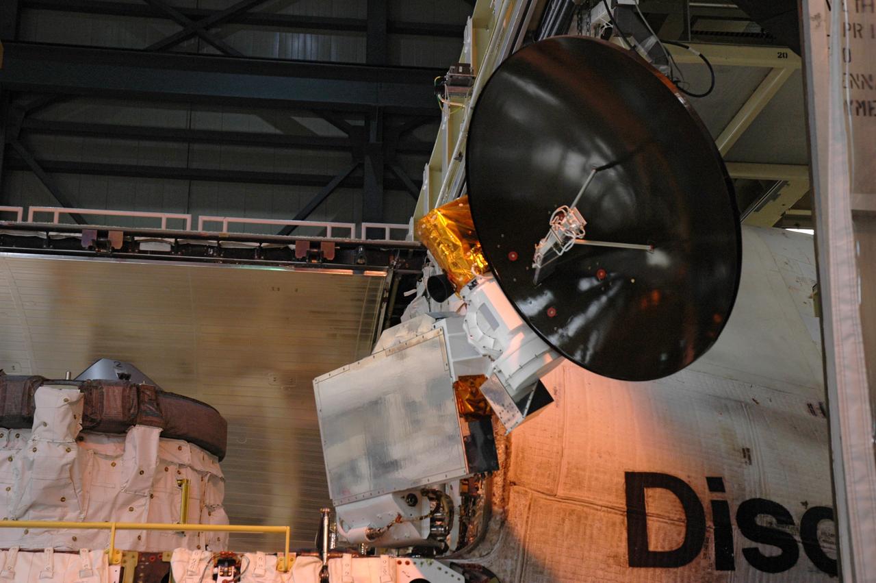 CAPE CANAVERAL, Fla. ---  In Orbiter Processing Facility Bay 3 at NASA's Kennedy Space Center, space shuttle Discovery's payload bay doors are closing.  Seen at center is a Ku-band antenna that can be used on orbit to transmit and receive information from the ground through the Tracking and Data Relay Satellite  system.   Discovery is the designated vehicle on the STS-124 mission to the International Space Station.  On the mission, the shuttle will transport the Kibo Japanese Experiment Module - Pressurized Module and the Japanese Remote Manipulator System. The payload will be installed at the launch pad.  Launch is targeted for May 25.  Photo credit: NASA/Chris Rhodes