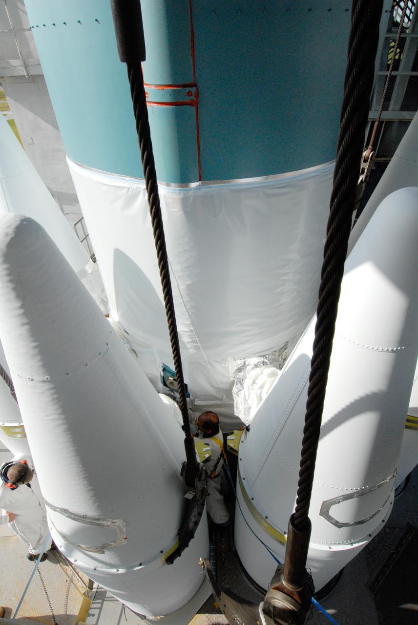 CAPE CANAVERAL, Fla. ---  In the mobile service tower on Pad 17-B at Cape Canaveral Air Force Station in Florida, United Launch Alliance technicians secure the bolts on the last set of three solid rocket boosters being mated to the Delta II rocket for the launch of  NASA's Gamma-ray Large Area Space Telescope, or GLAST. Because the Delta rocket is configured as a Delta II 7920 Heavy, the boosters are larger than those used on the standard configuration. The GLAST is a powerful space observatory that will explore the Universe's ultimate frontier, where nature harnesses forces and energies far beyond anything possible on Earth;  probe some of science's deepest questions, such as what our Universe is made of, and search for new laws of physics; explain how black holes accelerate jets of material to nearly light speed; and help crack the mystery of stupendously powerful explosions known as gamma-ray bursts.  Launch is currently planned in a window between 11:45 a.m. and 1:40 p.m. May 16.  Photo credit: NASA/Troy Cryder
