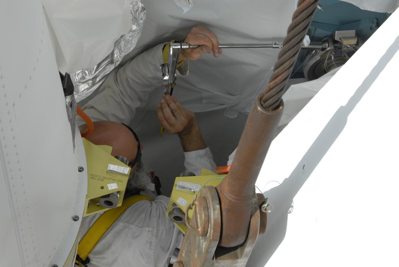 CAPE CANAVERAL, Fla. ---  In the mobile service tower on Pad 17-B at Cape Canaveral Air Force Station in Florida, United Launch Alliance technicians secure the bolts on the last set of three solid rocket boosters being mated to the Delta II rocket for the launch of  NASA's Gamma-ray Large Area Space Telescope, or GLAST. Because the Delta rocket is configured as a Delta II 7920 Heavy, the boosters are larger than those used on the standard configuration.  The GLAST is a powerful space observatory that will explore the Universe's ultimate frontier, where nature harnesses forces and energies far beyond anything possible on Earth;  probe some of science's deepest questions, such as what our Universe is made of, and search for new laws of physics; explain how black holes accelerate jets of material to nearly light speed; and help crack the mystery of stupendously powerful explosions known as gamma-ray bursts.  Launch is currently planned in a window between 11:45 a.m. and 1:40 p.m. May 16.  Photo credit: NASA/Troy Cryder