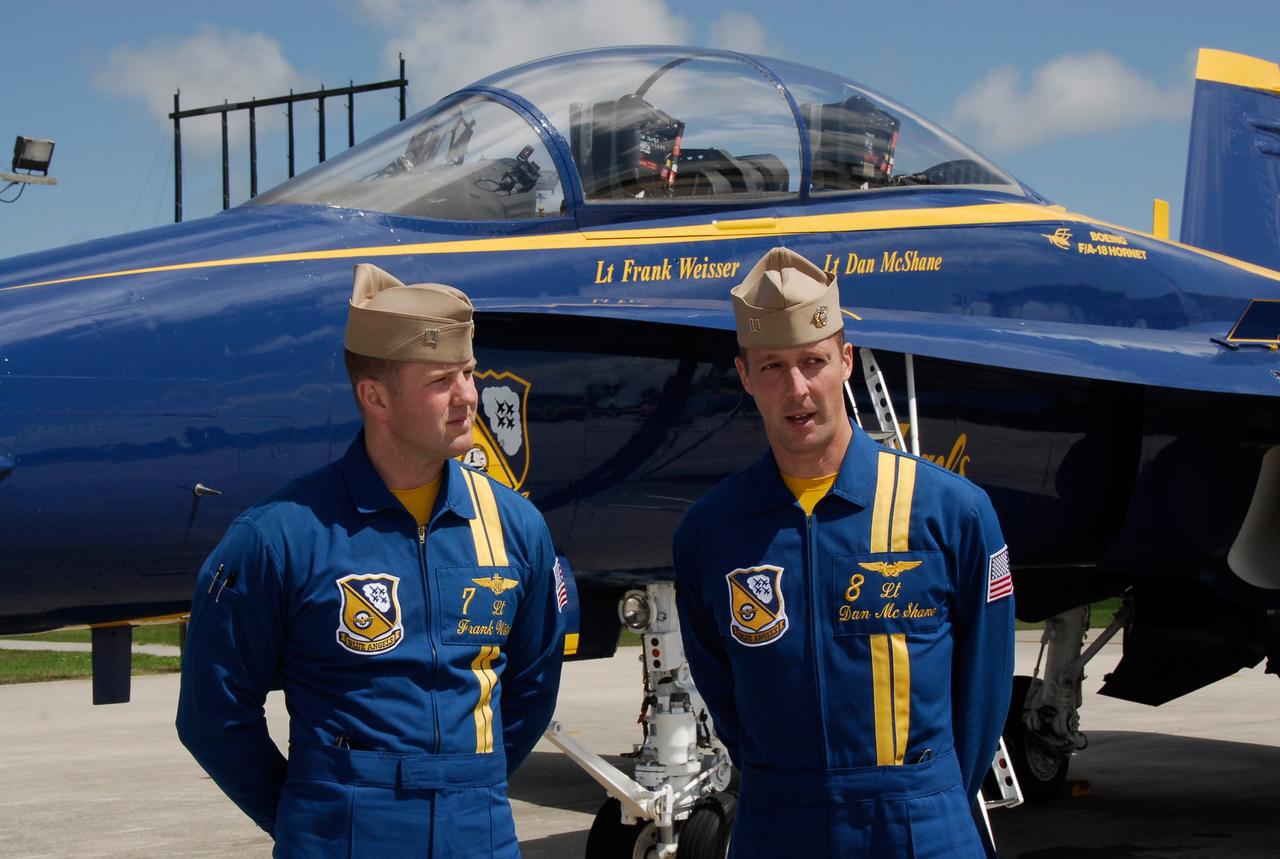 CAPE CANAVERAL, Fla. -- Blue Angel pilots Lt. Frank Weisser and Lt. Dan McShane arrive at NASA's Kennedy Space Center.  Behind them is one of the U.S. Navy F-18 Hornets flown by the Blue Angels.  The pilots flew into Kennedy to begin preparations for their involvement in the second annual Space & Air Show at Kennedy Space Center Nov. 8-9.   The air show will be only the second time the Blue Angels have performed at Kennedy.  Their precision flight team will perform high-speed passes, fast rolls, mirror formations, tight turns and their signature Delta formation showcasing the capabilities of the powerful aircraft.  The 2008 Space & Air Show will include aircraft displays and space-related exhibits on the ground and plenty of action in the skies over Kennedy.  Returning to the show is the 920th Rescue Wing, an Air Force Reserve Command combat search and rescue unit based at Patrick Air Force Base in Central Florida. Also, more than 20 astronauts and special guests will be on hand to personally meet guests, pose for photos and sign memorabilia.  Photo credit: NASA/Kim Shiflett