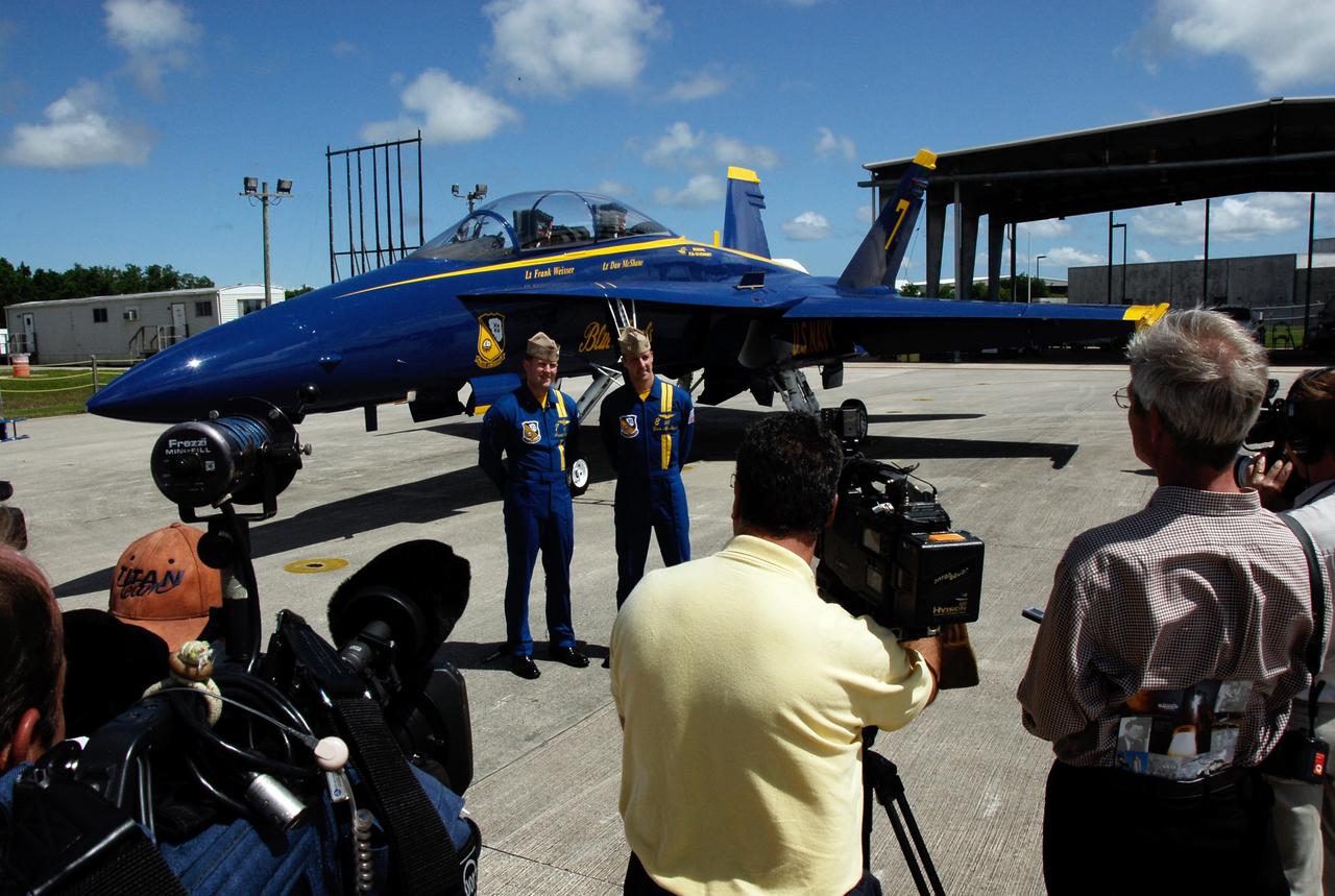 CAPE CANAVERAL, Fla. -- Blue Angel pilots Lt. Frank Weisser and Lt. Dan McShane pose for the media in front of one of the U.S. Navy F-18 Hornets flown by the Blue Angels.  The pilots flew into NASA's Kennedy Space Center to begin preparations for their involvement in the second annual Space & Air Show at Kennedy Space Center Nov. 8-9.   The air show will be only the second time the Blue Angels have performed at Kennedy.  Their precision flight team will perform high-speed passes, fast rolls, mirror formations, tight turns and their signature Delta formation showcasing the capabilities of the powerful aircraft.  The 2008 Space & Air Show will include aircraft displays and space-related exhibits on the ground and plenty of action in the skies over Kennedy.  Returning to the show is the 920th Rescue Wing, an Air Force Reserve Command combat search and rescue unit based at Patrick Air Force Base in Central Florida. Also, more than 20 astronauts and special guests will be on hand to personally meet guests, pose for photos and sign memorabilia.  Photo credit: NASA/Kim Shiflett