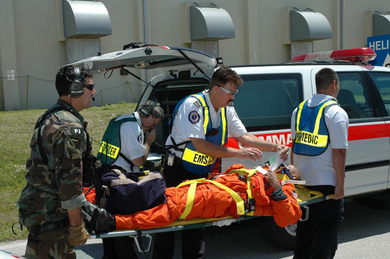 CAPE CANAVERAL, Fla. --   A group of NASA and contractor workers from Kennedy Space Center and other NASA centers, along with the Department of Defense, participate in a flight crew evacuation drill, also referred to as the Mode II/IV Simulation, from Launch Pad 39B. During the exercise, an emergency condition during launch countdown was simulated and participants did their parts to perform an emergency egress of the flight and ground crew.  Fire Rescue and Closeout Crew workers transported the flight and ground crews to a triage site. Simulated injuries were treated and those with serious injuries were evacuated by helicopter to local hospitals.  Photo credit: NASA/Jim Grossmann