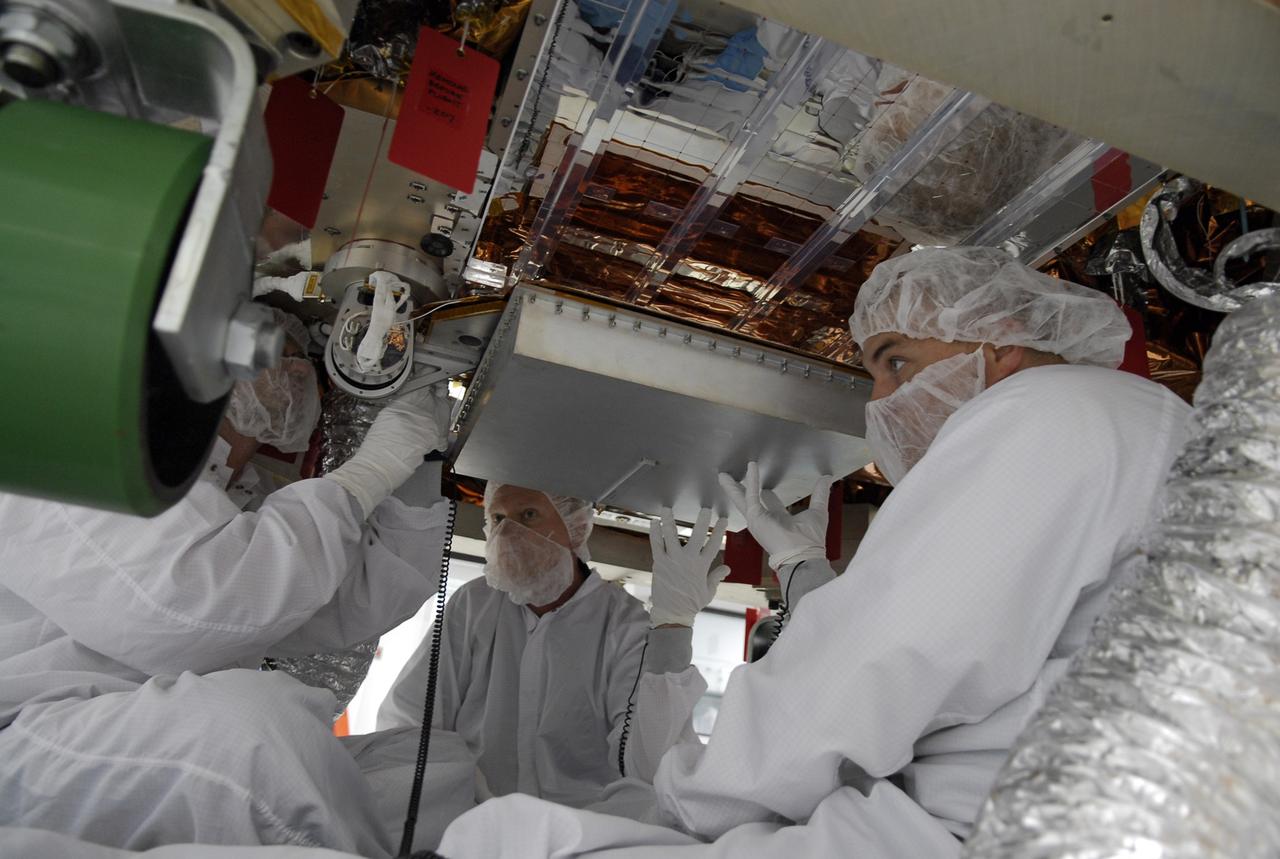 CAPE CANAVERAL, Fla. -- In the Astrotech payload processing facility near NASA's Kennedy Space Center, General Dynamics technicians, sitting under the Gamma-ray Large Area Space Telescope, or GLAST, install a high-gain antenna on the spacecraft. The GLAST is a powerful space observatory that will explore the universe's ultimate frontier, where nature harnesses forces and energies far beyond anything possible on Earth; probe some of science's deepest questions, such as what our universe is made of, and search for new laws of physics; explain how black holes accelerate jets of material to nearly light speed; and help crack the mystery of stupendously powerful explosions known as gamma-ray bursts. Launch is currently planned in a window between 11:45 a.m. and 1:40 p.m. EDT May 16. Photo credit: NASA/Kim Shiflett