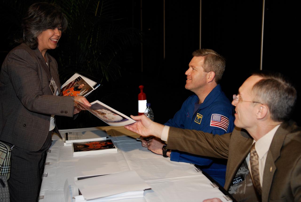 CAPE CANAVERAL, Fla. --  During a break in presentations at NASA’s Future Forum in Miami, astronaut Steve Frick and former astronaut Carl Walz sign autographs.  Frick served as commander of the STS-122 shuttle mission.  Walz is now director of NASA’s Advanced Capabilities Division. The forum focused on how space exploration benefits Florida's economy. The event, which included presentations and panels, was held at the University of Miami's BankUnited Center.  Among those participating were NASA Deputy Administrator Shana Dale, astronaut Carl Walz, director of the Advanced Capabilities Division in NASA's Exploration Systems Mission Directorate, and Russell Romanella, director, International Space Station and Spacecraft Processing.   Photo credit: NASA/Kim Shiflett