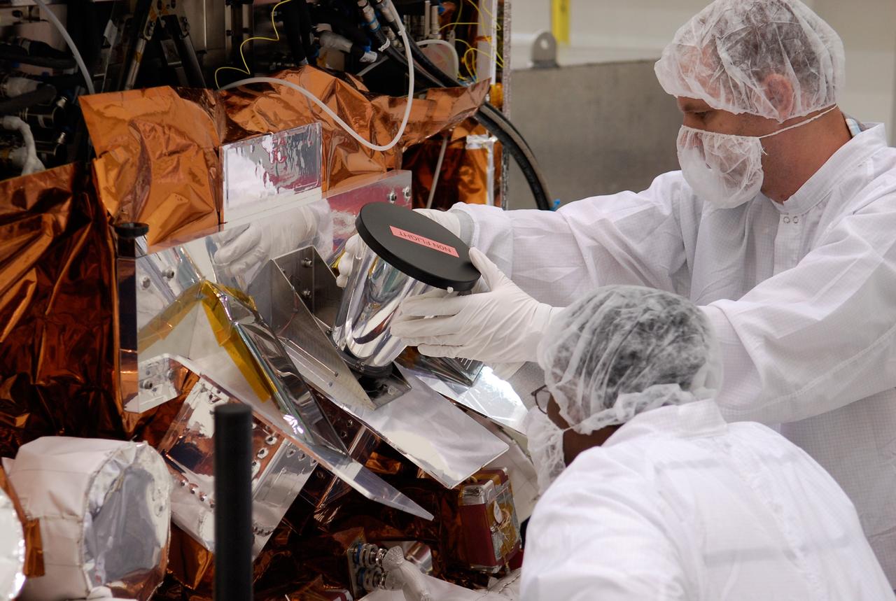 CAPE CANAVERAL, Fla. -- At the Astrotech payload processing facility in Titusville, Fla., workers install one of the star tracker sun shades on NASA's Gamma-ray Large Area Space Telescope, or GLAST, spacecraft. The GLAST is a powerful space observatory that will explore the Universe's ultimate frontier, where nature harnesses forces and energies far beyond anything possible on Earth; probe some of science's deepest questions, such as what our Universe is made of, and search for new laws of physics; explain how black holes accelerate jets of material to nearly light speed; and help crack the mystery of stupendously powerful explosions known as gamma-ray bursts. A launch date is still to be determined. Photo credit: NASA/Kim Shiflett