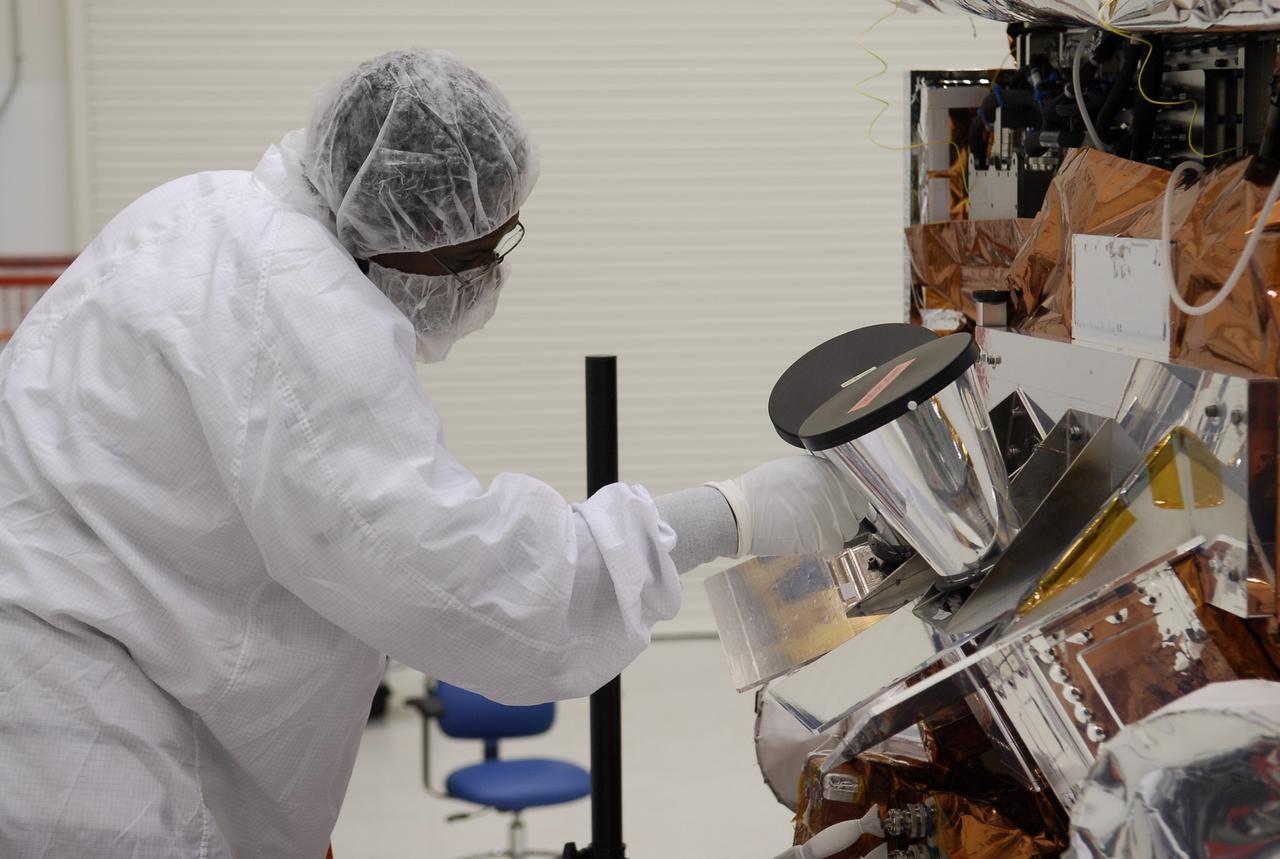 CAPE CANAVERAL, Fla. -- At the Astrotech payload processing facility in Titusville, Fla., a worker adjusts the star tracker sun shades installed on NASA's Gamma-ray Large Area Space Telescope, or GLAST, spacecraft. The GLAST is a powerful space observatory that will explore the Universe's ultimate frontier, where nature harnesses forces and energies far beyond anything possible on Earth; probe some of science's deepest questions, such as what our Universe is made of, and search for new laws of physics; explain how black holes accelerate jets of material to nearly light speed; and help crack the mystery of stupendously powerful explosions known as gamma-ray bursts. A launch date is still to be determined. Photo credit: NASA/Kim Shiflett
