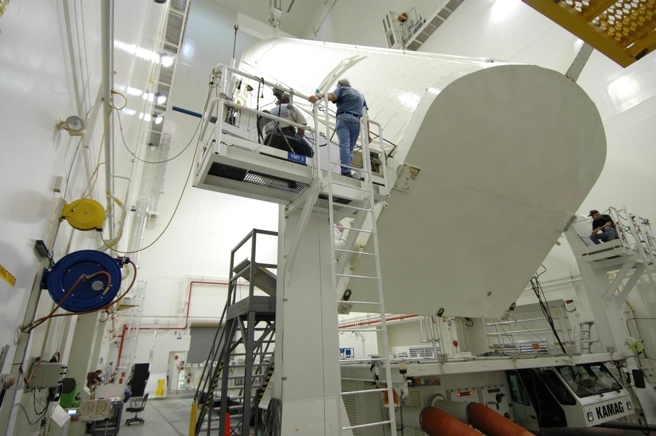 CAPE CANAVERAL, Fla. -- In the Vertical Integration Facility at NASA's Kennedy Space Center, workers on either side monitor the progress of the payload canister as it is raised to a vertical position.  The canister contains the Japanese Experiment Module -Pressurized Module, which will be transported to Launch Pad 39A for space shuttle Discovery’s STS-124 mission.  At the pad, the payload will be transferred from the canister into the payload changeout room on the rotating service structure.  The changeout room is the enclosed, environmentally controlled portion of the service structure that supports cargo delivery to the pad and subsequent vertical installation into an orbiter's payload bay. On the mission, the STS-124 crew will transport the JEM as well as the Japanese Remote Manipulator System to the International Space Station.  The launch of Discovery is targeted for May 31.    Photo credit: NASA/Jim Grossmann