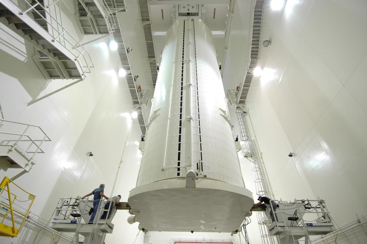 CAPE CANAVERAL, Fla. -- In the Vertical Integration Facility at NASA's Kennedy Space Center, workers on either side of the payload canister check its condition after being rotated from a horizontal position. The canister contains the Japanese Experiment Module -Pressurized Module, which will be transported to Launch Pad 39A for space shuttle Discovery’s STS-124 mission.  At the pad, the payload will be transferred from the canister into the payload changeout room on the rotating service structure.  The changeout room is the enclosed, environmentally controlled portion of the service structure that supports cargo delivery to the pad and subsequent vertical installation into an orbiter's payload bay. On the mission, the STS-124 crew will transport the JEM as well as the Japanese Remote Manipulator System to the International Space Station.  The launch of Discovery is targeted for May 31.    Photo credit: NASA/Jim Grossmann