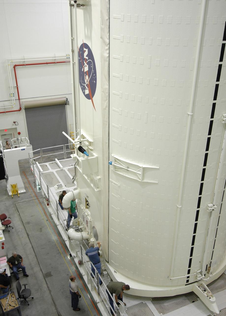 CAPE CANAVERAL, Fla. -- In the Vertical Integration Facility at NASA's Kennedy Space Center, workers check the placement of the payload canister after it was lowered onto the payload canister transporter.  The canister contains the Japanese Experiment Module -Pressurized Module, which will be transported to Launch Pad 39A for space shuttle Discovery’s STS-124 mission.  At the pad, the payload will be transferred from the canister into the payload changeout room on the rotating service structure.  The changeout room is the enclosed, environmentally controlled portion of the service structure that supports cargo delivery to the pad and subsequent vertical installation into an orbiter's payload bay. On the mission, the STS-124 crew will transport the JEM as well as the Japanese Remote Manipulator System to the International Space Station.  The launch of Discovery is targeted for May 31.    Photo credit: NASA/Jim Grossmann