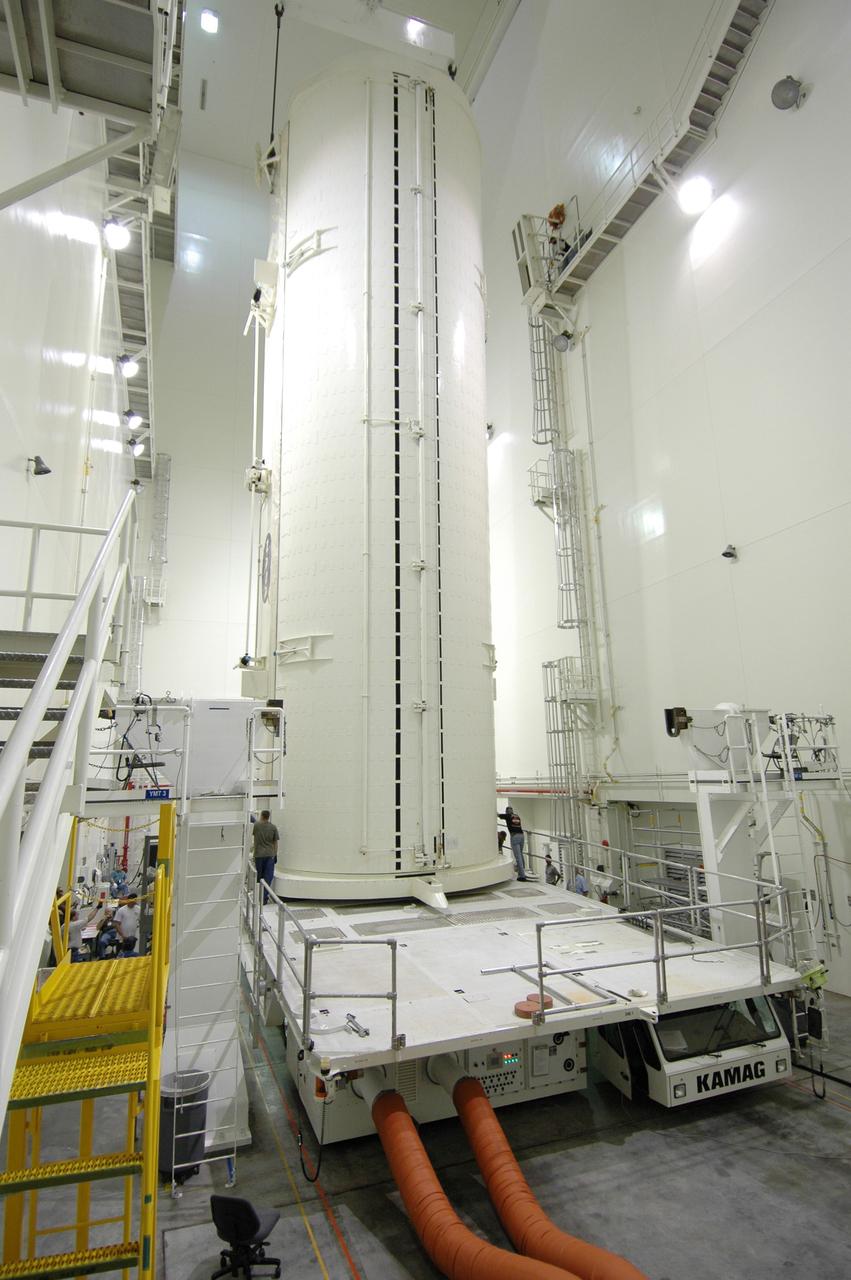 CAPE CANAVERAL, Fla. -- In the Vertical Integration Facility at NASA's Kennedy Space Center, workers check the placement of the payload canister after it was lowered onto the payload canister transporter.  The canister contains the Japanese Experiment Module -Pressurized Module, which will be transported to Launch Pad 39A for space shuttle Discovery’s STS-124 mission. At the pad, the payload will be transferred from the canister into the payload changeout room on the rotating service structure.  The changeout room is the enclosed, environmentally controlled portion of the service structure that supports cargo delivery to the pad and subsequent vertical installation into an orbiter's payload bay. On the mission, the STS-124 crew will transport the JEM as well as the Japanese Remote Manipulator System to the International Space Station.  The launch of Discovery is targeted for May 31.    Photo credit: NASA/Jim Grossmann