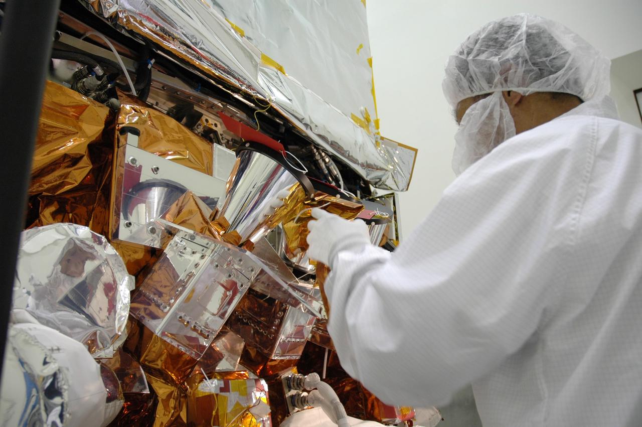 CAPE CANAVERAL, Fla. – At the Astrotech payload processing facility, technicians install insulation blankets around the star tracker sunshades on NASA's Gamma-ray Large Area Space Telescope, or GLAST, spacecraft. The GLAST is a powerful space observatory that will explore the Universe's ultimate frontier, where nature harnesses forces and energies far beyond anything possible on Earth; probe some of science's deepest questions, such as what our Universe is made of, and search for new laws of physics; explain how black holes accelerate jets of material to nearly light speed; and help crack the mystery of stupendously powerful explosions known as gamma-ray bursts. A launch date is still to be determined. Photo credit: NASA/Jim Grossmann