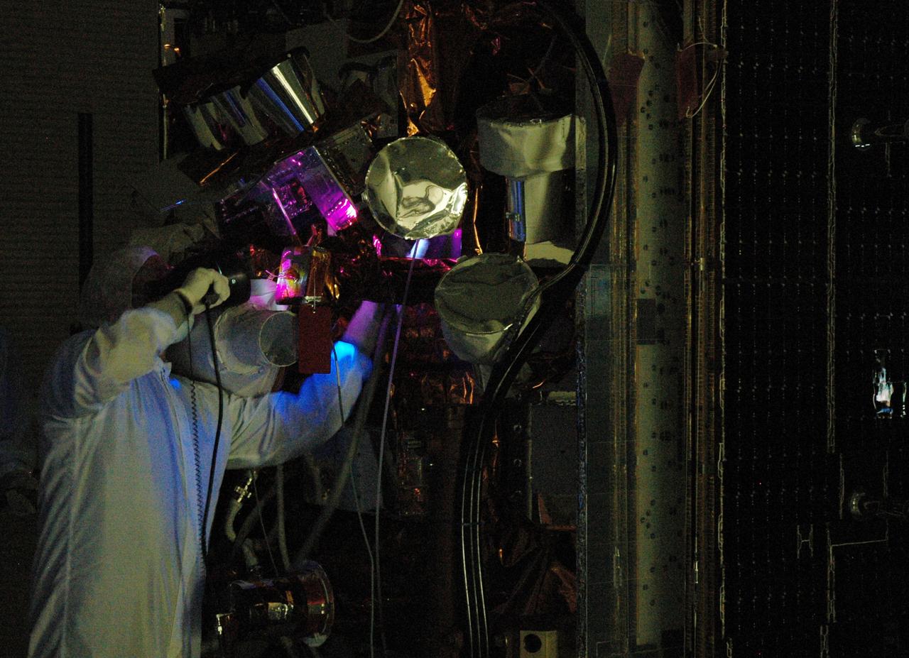CAPE CANAVERAL, Fla. –  At the Astrotech payload processing facility, technicians conduct black light inspection on NASA's Gamma-ray Large Area Space Telescope, or GLAST,  spacecraft.  The GLAST is a powerful space observatory that will explore the Universe's ultimate frontier, where nature harnesses forces and energies far beyond anything possible on Earth;  probe some of science's deepest questions, such as what our Universe is made of, and search for new laws of physics; explain how black holes accelerate jets of material to nearly light speed; and help crack the mystery of stupendously powerful explosions known as gamma-ray bursts. A launch date is still to be determined.   Photo credit: NASA/Jim Grossmann