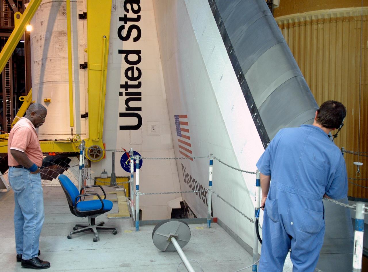 CAPE CANAVERAL, Fla. – In high bay 3 of the Vehicle Assembly Building at NASA's Kennedy Space Center, United Space Alliance technicians mark the progress of space shuttle Discovery as it is lowered onto the mobile launcher platform. Discovery will be mated with the solid rocket boosters and external tank already stacked there in preparation for the launch on the upcoming STS-124 mission to the International Space Station. On the mission, the STS-124 crew will transport the Japanese Experiment Module - Pressurized Module and the Japanese Remote Manipulator System to the space station. Launch of Discovery is targeted for May 31 Photo credit: NASA/Jim Grossmann
