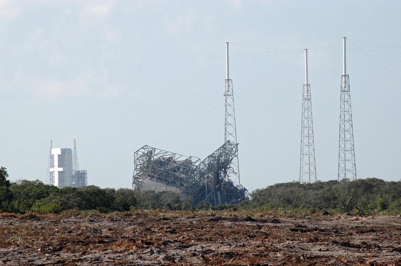 CAPE CANAVERAL, Fla. – The upper part of the mobile service tower, or gantry, at Space Launch Complex 40 on Cape Canaveral Air Force Station lies on the ground after implosion. The tall lightning towers around it remain. This mammoth structure, with its cavernous clean room, was used for the final spacecraft launch preparations for NASA’s Cassini spacecraft, currently orbiting Saturn. The launch occurred on Oct. 15, 1997, aboard an Air Force Titan IV-Centaur rocket. The facilities at the pad are being dismantled to make room for the construction of launch pad access and servicing facilities for the new Falcon rockets to be launched by Space Exploration Technologies, known as SpaceX. Photo credit: NASA/Cory Huston
