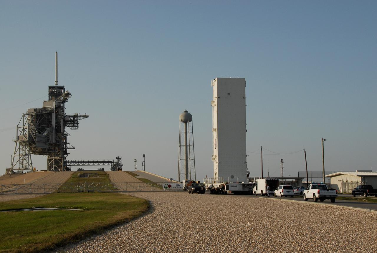 CAPE CANAVERAL, Fla. -- Positioned on its 12-wheeled, 24-tire transporter, the payload canister with the STS-124 mission payload, Japanese Experiment Module - Pressurized Module and the Japanese Remote Manipulator System, or RMS, inside, approaches the ramp to Launch Pad 39A at NASA's Kennedy Space Center. The transporter is 65 feet long and 23 feet wide. The transporter’s wheels are independently steerable, permitting it to move forward, backward, sideways or diagonally and to turn on its own axis like a carousel. It is equipped with pneumatic-actuated braking and hydrostat¬ic leveling and drive systems. It is steered from a two-seat operator cab mounted at one end. From the payload changeout room, the pressurized module and RMS will be transferred into space shuttle Discovery’s payload bay. Launch is targeted for May 31. Photo credit: NASA/Kim Shiflett