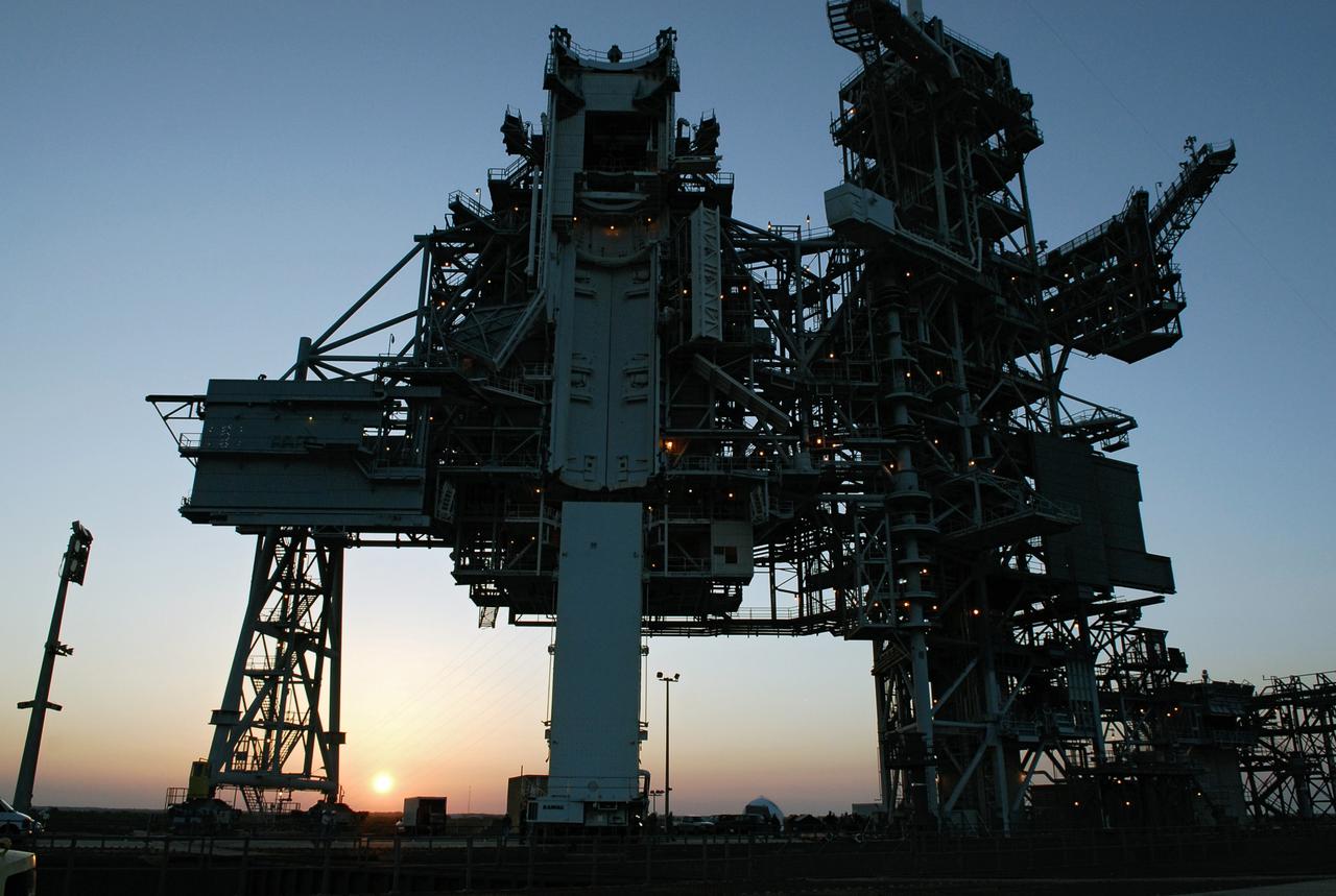 CAPE CANAVERAL, Fla. –    The sun sets behind Launch Pad 39A at NASA's Kennedy Space Center where the payload canister with the Japanese Experiment Module - Pressurized Module and the Japanese Remote Manipulator System, or RMS, inside awaits cargo transfer to the payload changeout room above.  The changeout room is the enclosed, environmentally controlled portion of the service structure that supports cargo delivery to the pad and subsequent vertical installation into an orbiter's payload bay. From the payload changeout room, the pressurized module and RMS then will be transferred into space shuttle Discovery’s payload bay.  Launch is targeted for May 31.  Photo credit: NASA/Kim Shiflett