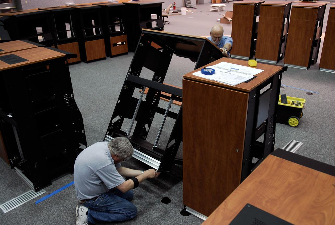 CAPE CANAVERAL, Fla. -- In Firing Room No. 1 in the Launch Control Center at NASA's Kennedy Space Center, workers put together another cabinet to hold equipment that will support the future Ares rocket launches as part of the Constellation Program. Future astronauts will ride to orbit on Ares I, which uses a single five-segment solid rocket booster, a derivative of the space shuttle's solid rocket booster, for the first stage. Ares will be launched from Pad 39B, which is being reconfigured from supporting space shuttle launches. The Launch Control Center firing rooms face the launch pads. Photo credit: NASA/Kim Shiflett