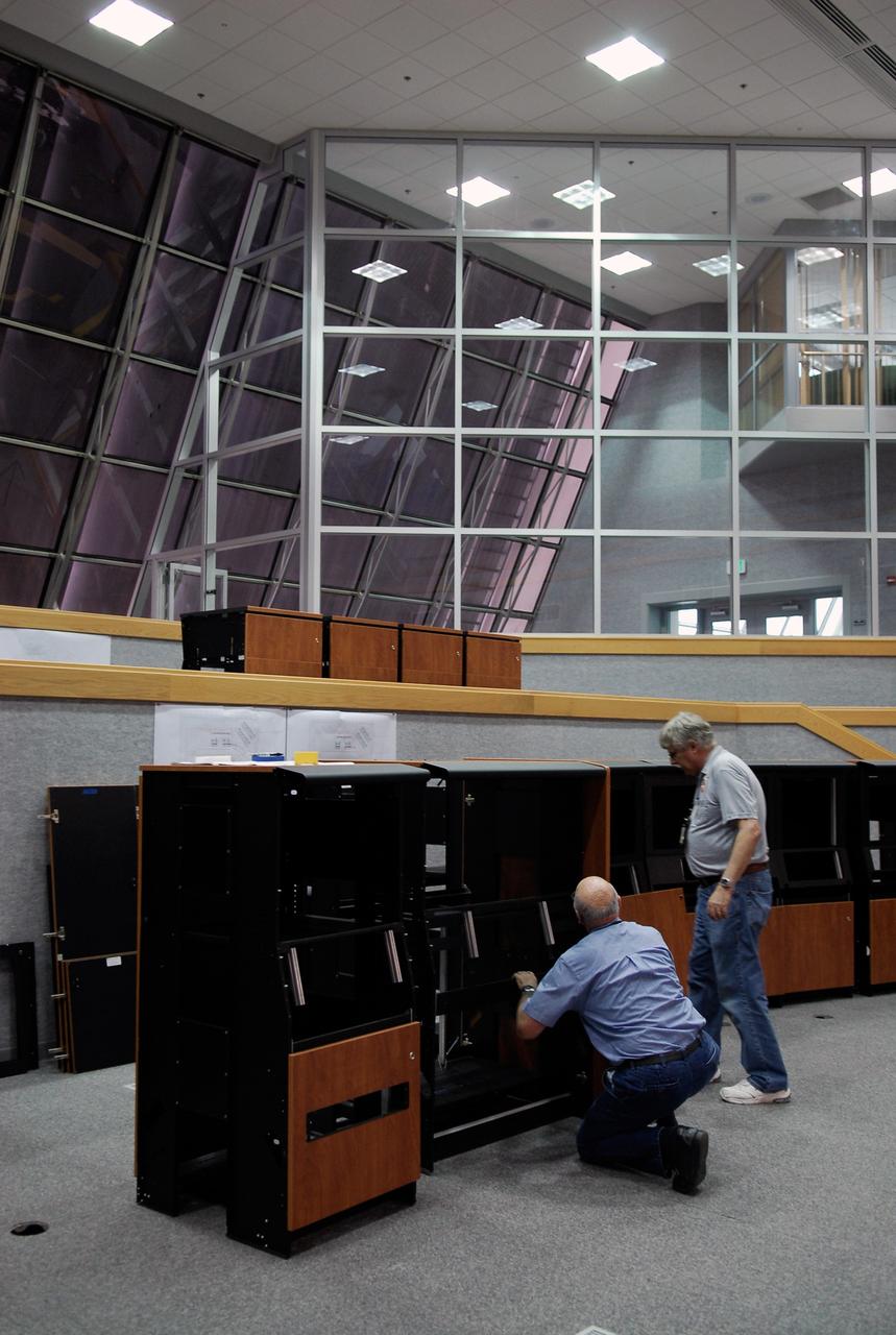 CAPE CANAVERAL, Fla. -- In Firing Room No. 1 in the Launch Control Center at NASA's Kennedy Space Center, workers put together another cabinet to hold equipment that will support the future Ares rocket launches as part of the Constellation Program. Future astronauts will ride to orbit on Ares I, which uses a single five-segment solid rocket booster, a derivative of the space shuttle's solid rocket booster, for the first stage. Ares will be launched from Pad 39B, which is being reconfigured from supporting space shuttle launches. The Launch Control Center firing rooms face the launch pads. Photo credit: NASA/Kim Shiflett