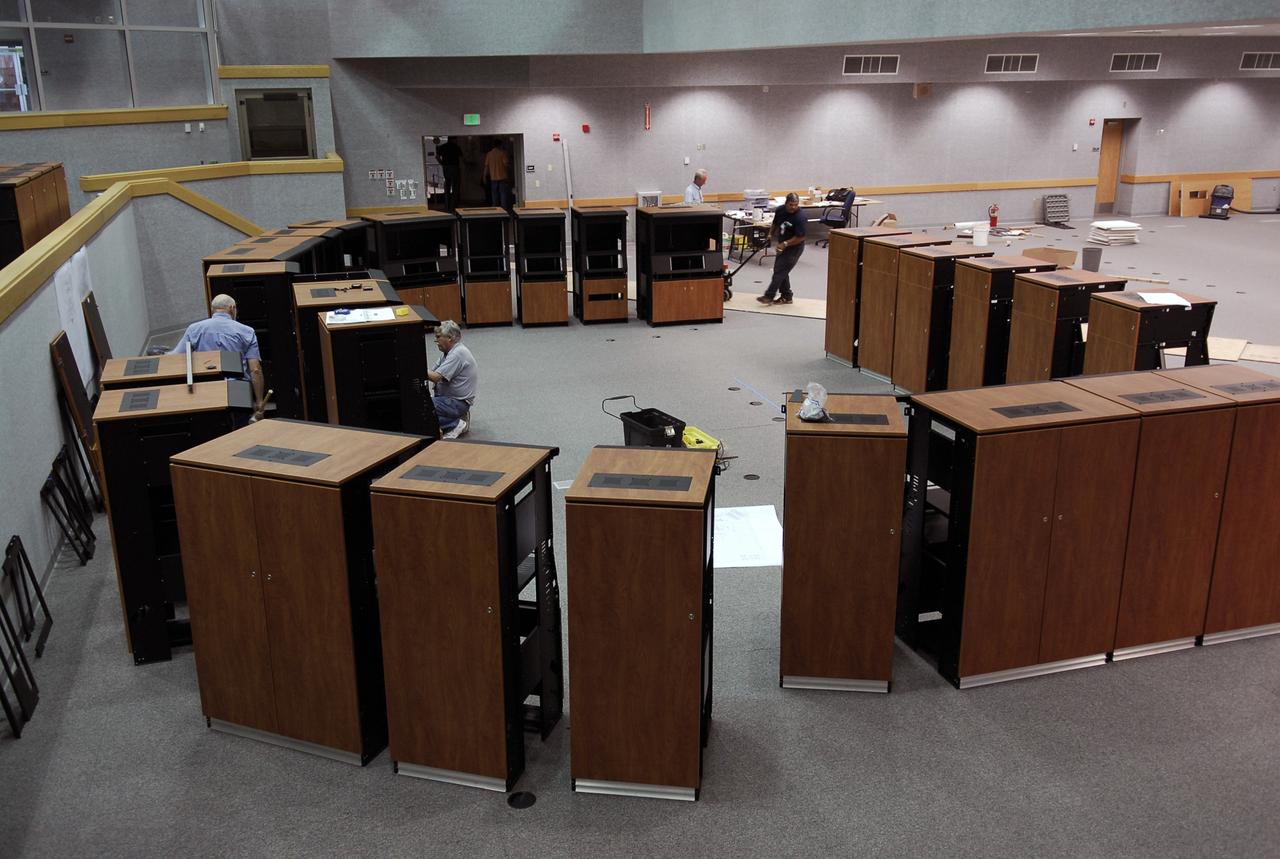 CAPE CANAVERAL, Fla. -- In Firing Room No. 1 in the Launch Control Center at NASA's Kennedy Space Center, workers line up the new equipment cabinets. The firing room will support the future Ares rocket launches as part of the Constellation Program. Future astronauts will ride to orbit on Ares I, which uses a single five-segment solid rocket booster, a derivative of the space shuttle's solid rocket booster, for the first stage. Ares will be launched from Pad 39B, which is being reconfigured from supporting space shuttle launches. The Launch Control Center firing rooms face the launch pads. Photo credit: NASA/Kim Shiflett